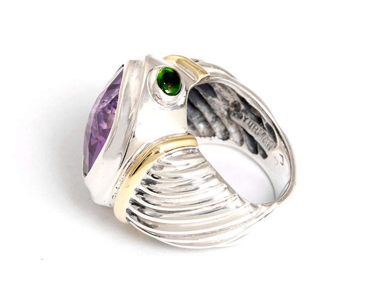 This beautiful 14k yellow gold and sterling silver David Yurman ring features  an amethyst in the center and one green tourmaline on each side.  The amethyst measures apx. 12 mm in length and apx. 14 mm in width. The ring is a size 5 and the total