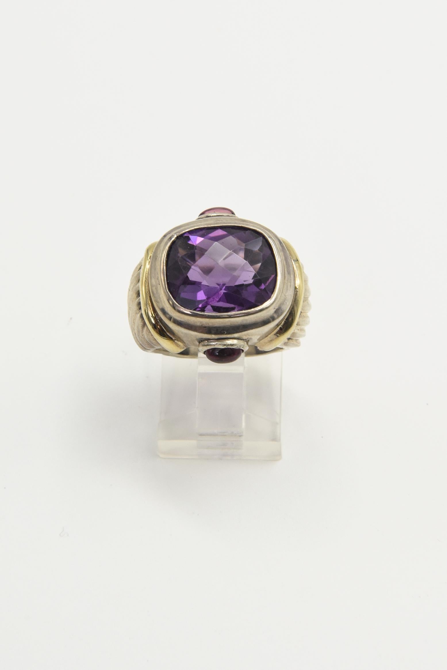 Vintage late 20th century David Yurman amethyst and garnet sterling silver and 14k gold Renaissance ring with cable band ring featuring a facetted cushion shaped amethyst and 2 cabochon garnets on the sides.  It has a 14k gold bar on the shoulders