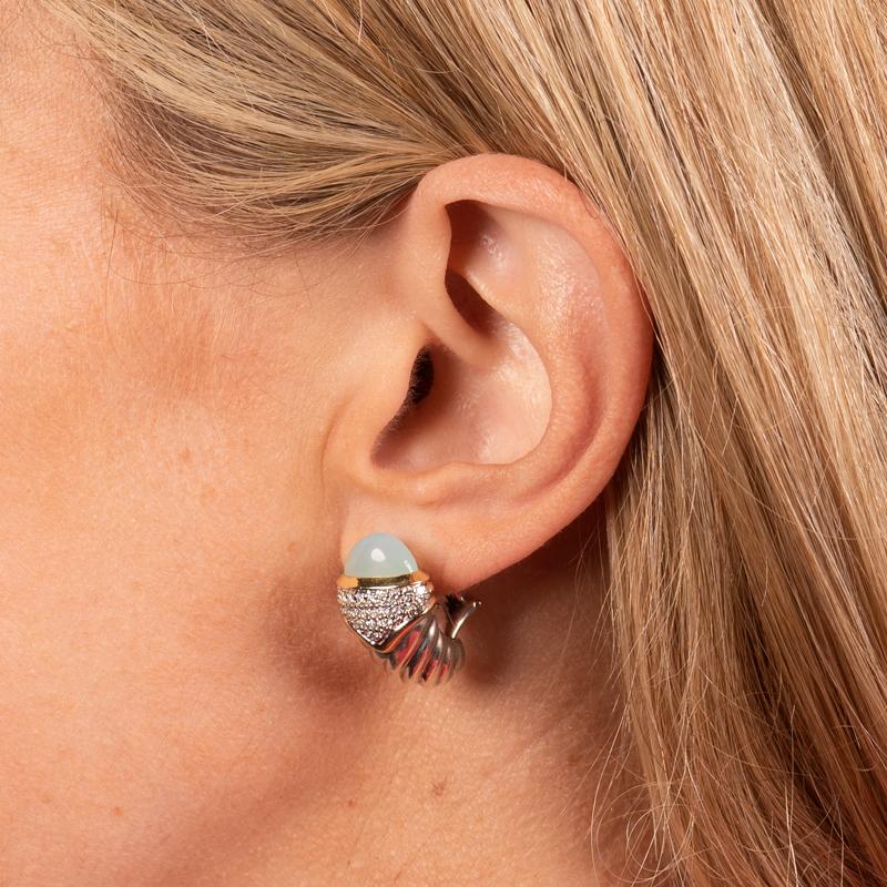 These cable shrimp earrings from David Yurman are crafted in sterling silver with 18 karat yellow gold accents. They feature pave set diamonds and aqua chalcedony. Omega post back. 
Condition: Good. A few small dents.