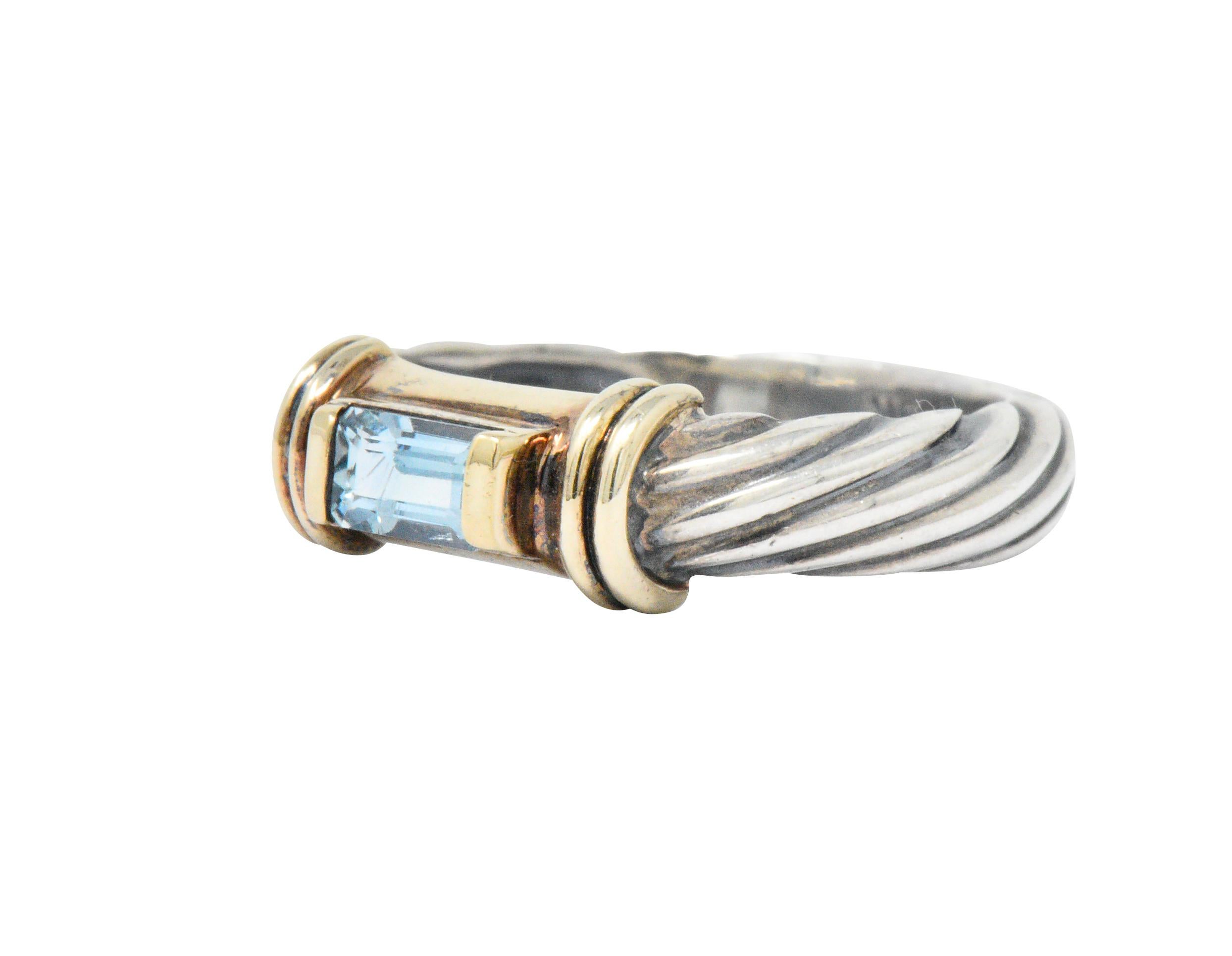 Centering an emerald cut blue topaz, pale to light blue

Prong set with elongated 14k gold tips on each end of stone

14k gold ribbed accents flank blue topaz

Sterling silver cable twist band

Signed D. Yurman Sterling and tested as 14k gold

Top