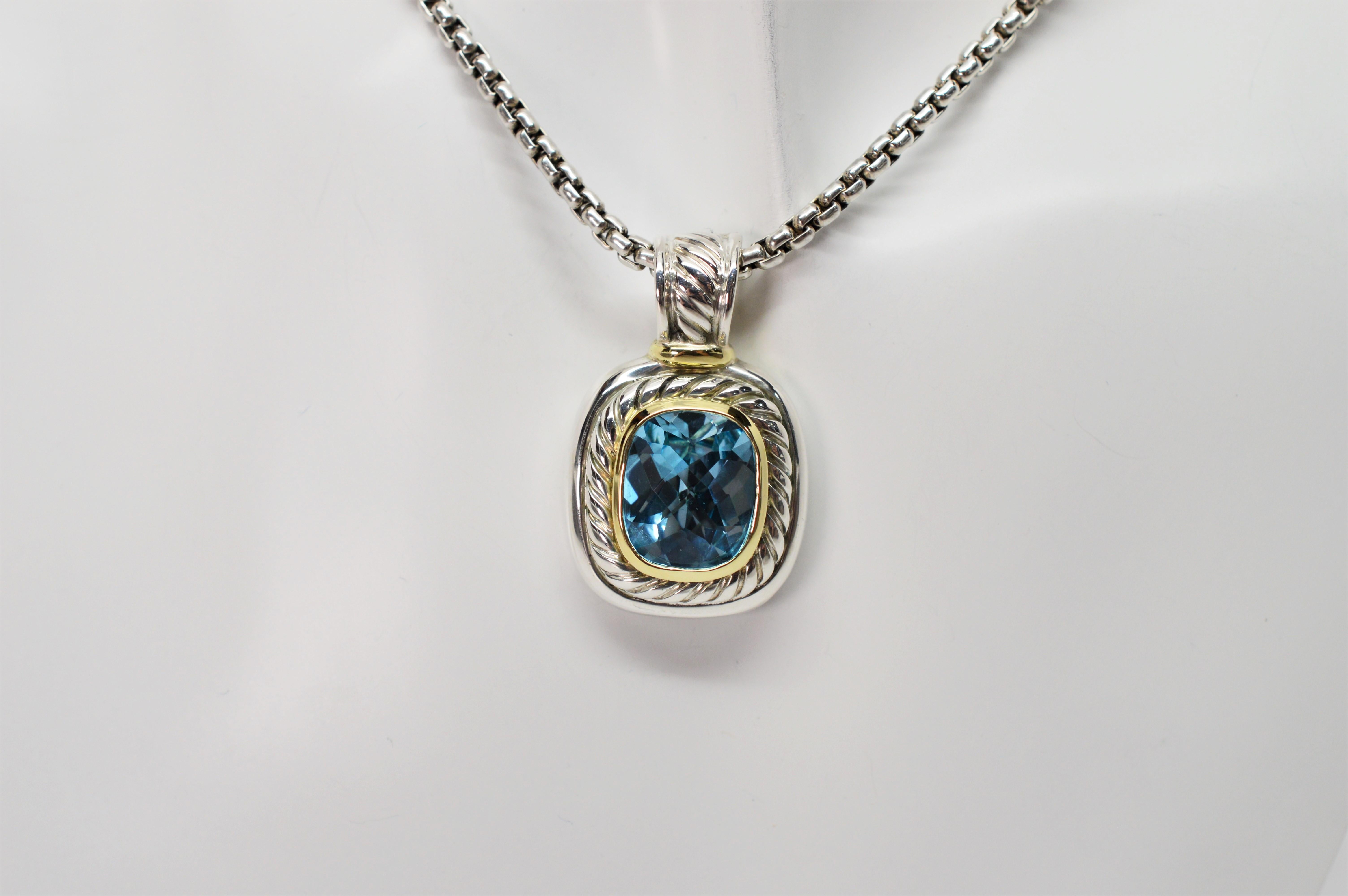 From the David Yurman Albion Collection, featuring a faceted vivid blue topaz, more than five carats, that has been bezel set in fourteen karat 14k yellow gold with a surrounding sterling silver cable design. The sterling silver pendant measures