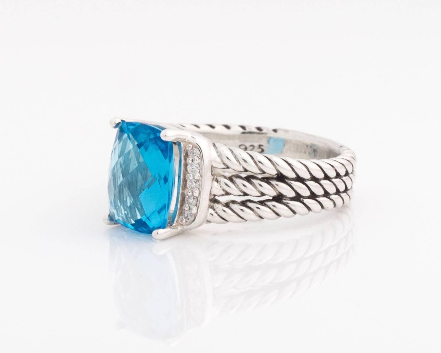David Yurman Petite Wheaton Ring with Blue Topaz, Diamonds, Sterling Silver 

Features a 10 x 8 millimeters Faceted Blue Topaz center stone flanked by one row of Pave Diamonds on each side. The medium blue Topaz is prong set in Sterling Silver. The