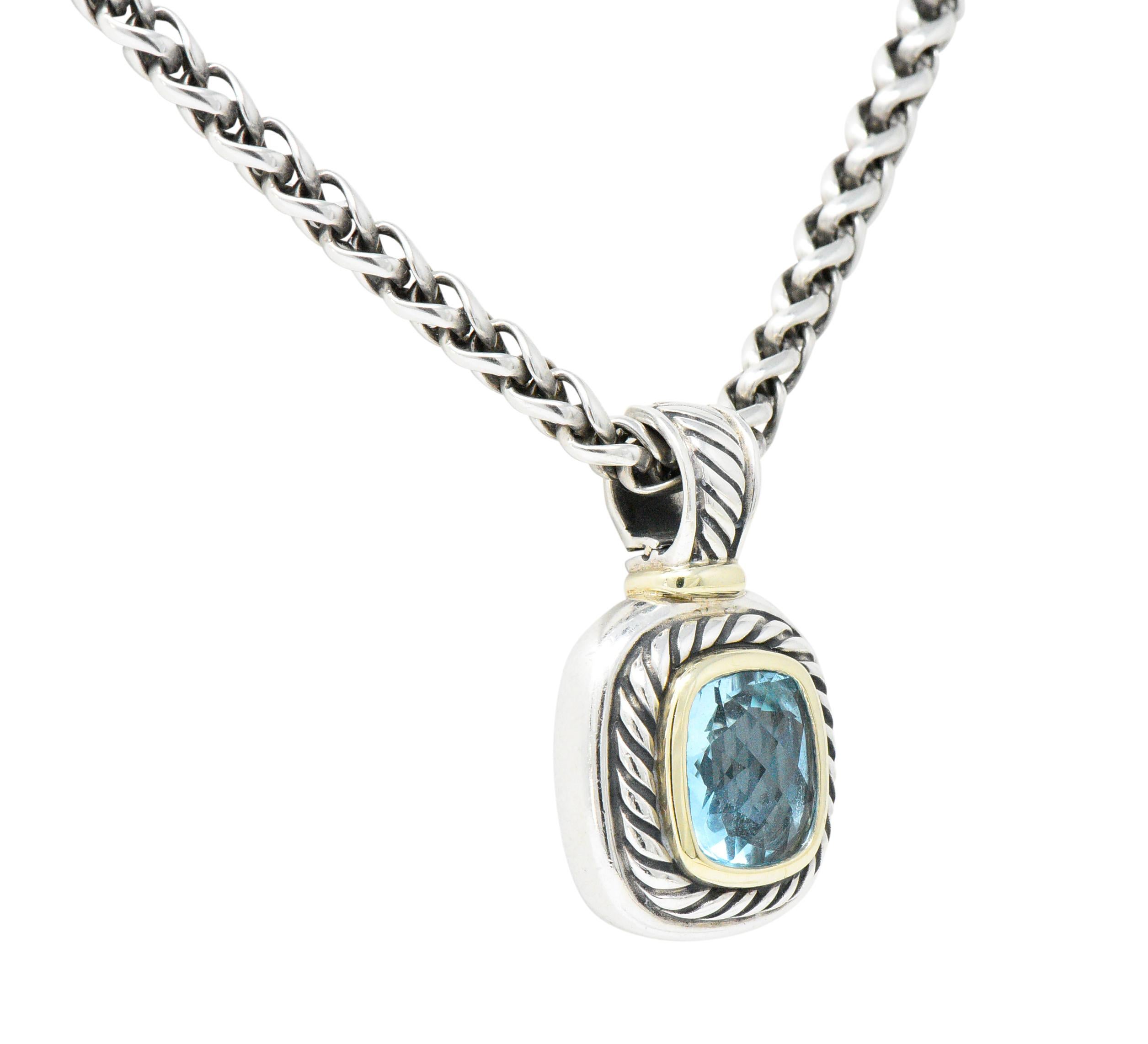 Featuring a bezel set faceted blue topaz, vivid bright blue

Within a sterling silver cable twist pendant including 14k gold border around the blue topaz

Hinged and removable pendant

Measuring 1 3/16