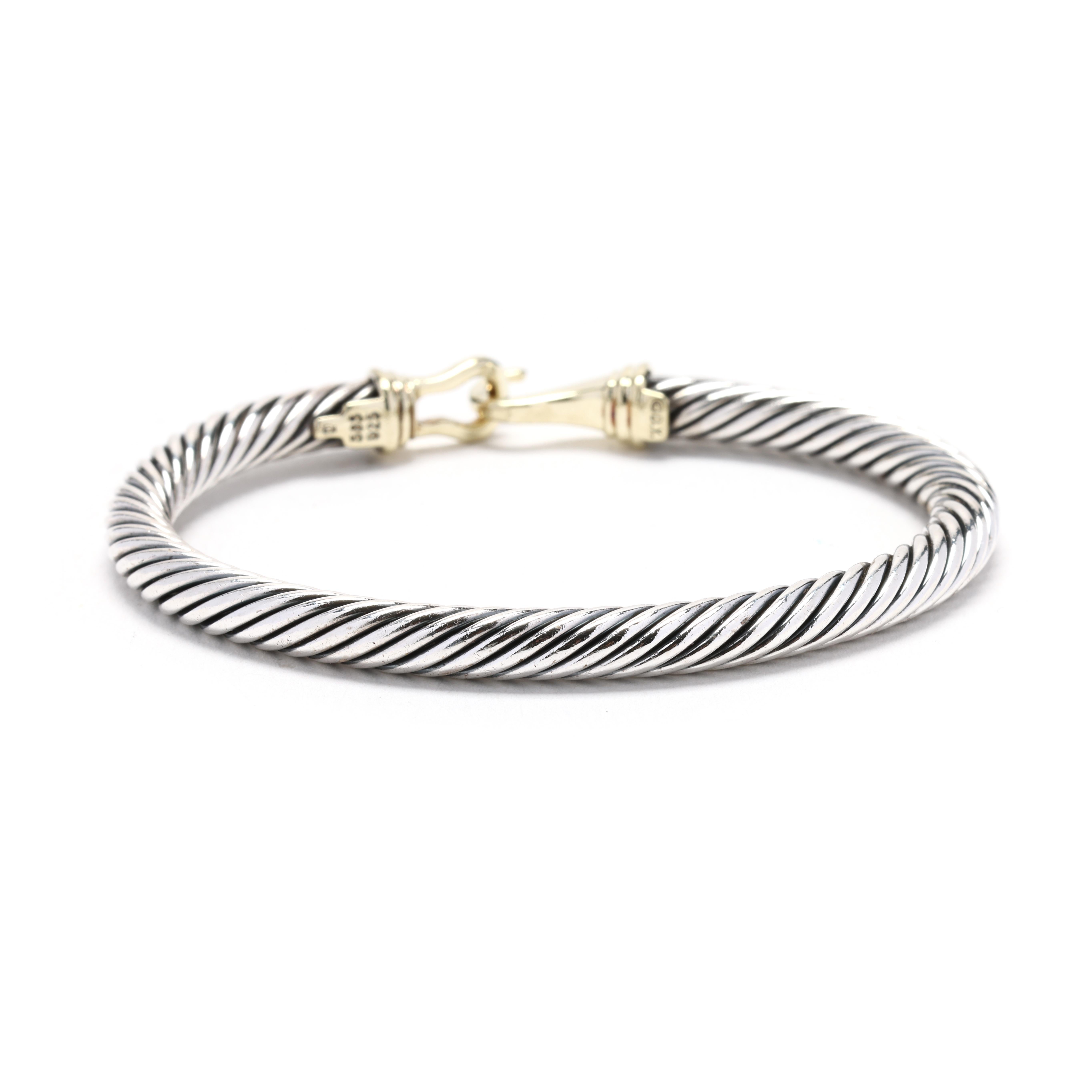 This stunning David Yurman buckle cuff bracelet is a true statement piece. Crafted from sterling silver and featuring a 14k yellow gold buckle detail, this bracelet is a perfect blend of classic and modern elements. The twisted cable motif, which is