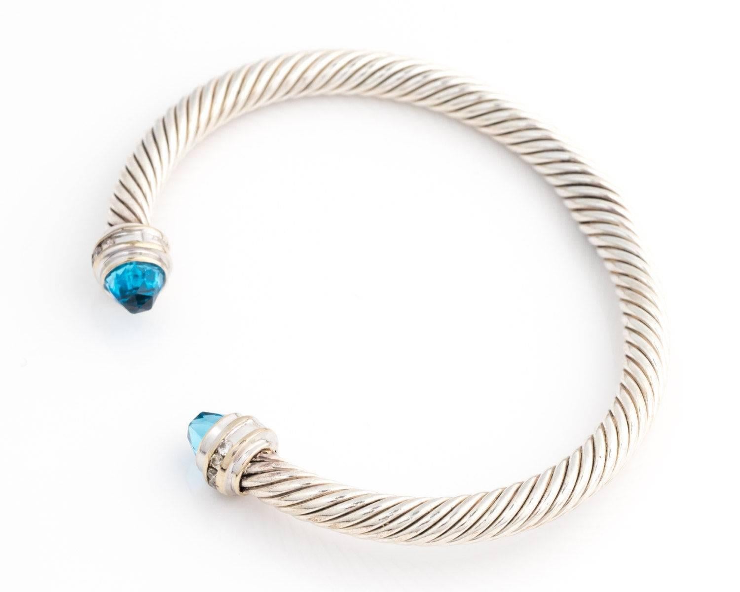 2000s David Yurman Cable Classics Bracelet with Blue Topaz, Diamonds, Sterling Silver, 18 Karat White Gold

Features Sterling Silver Cable with Blue Topaz Cabochon Ends and Diamond Accents. Each end is set with a sky Blue Topaz. A Diamond accented