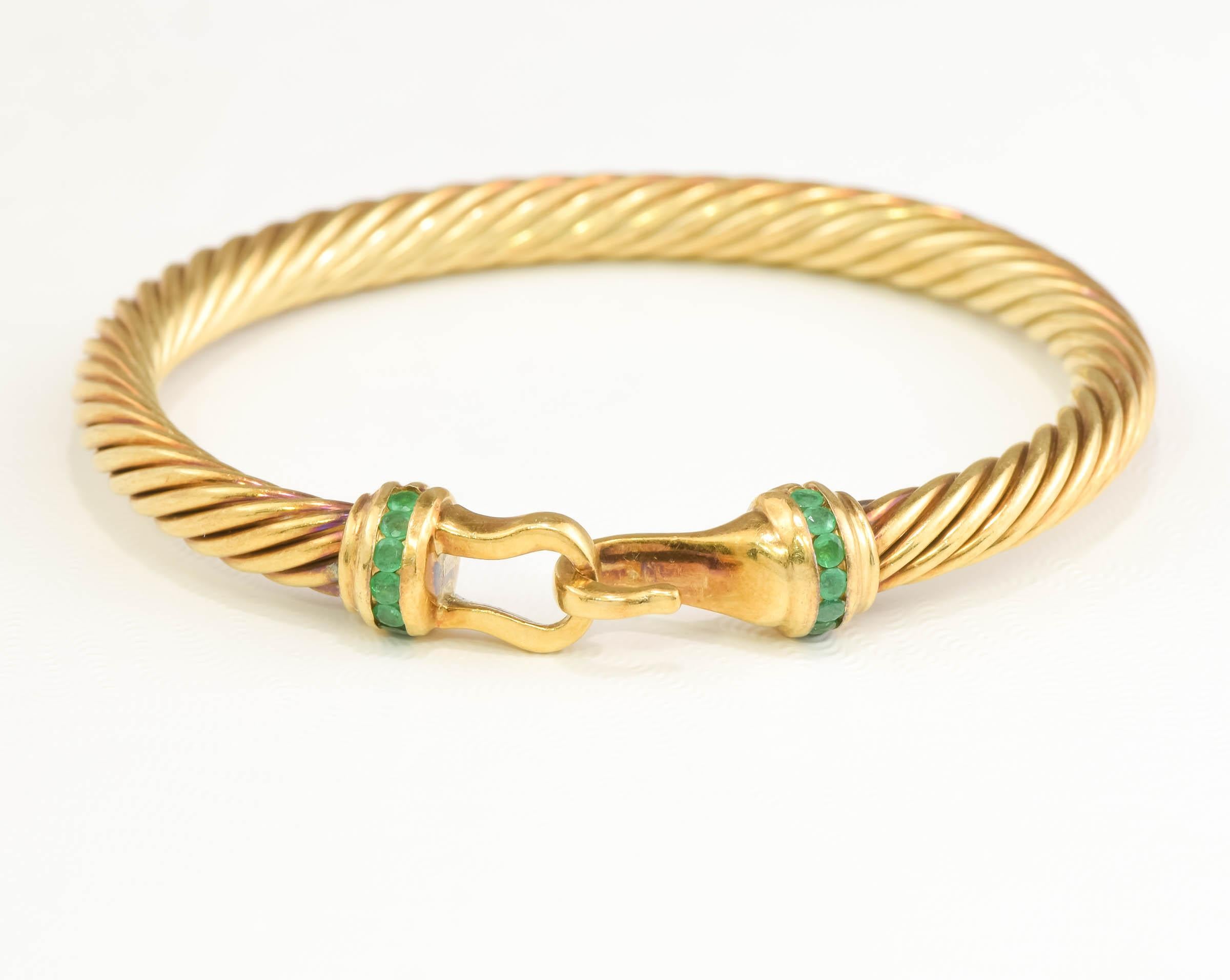 Offered is a lovely classic gold & emerald bangle bracelet by David Yurman, beautifully made for a small wrist.

Finely crafted of richly hued solid 14K yellow gold, the bracelet measures approximately 4.94 mm wide and weighs a hefty 16.82 grams on