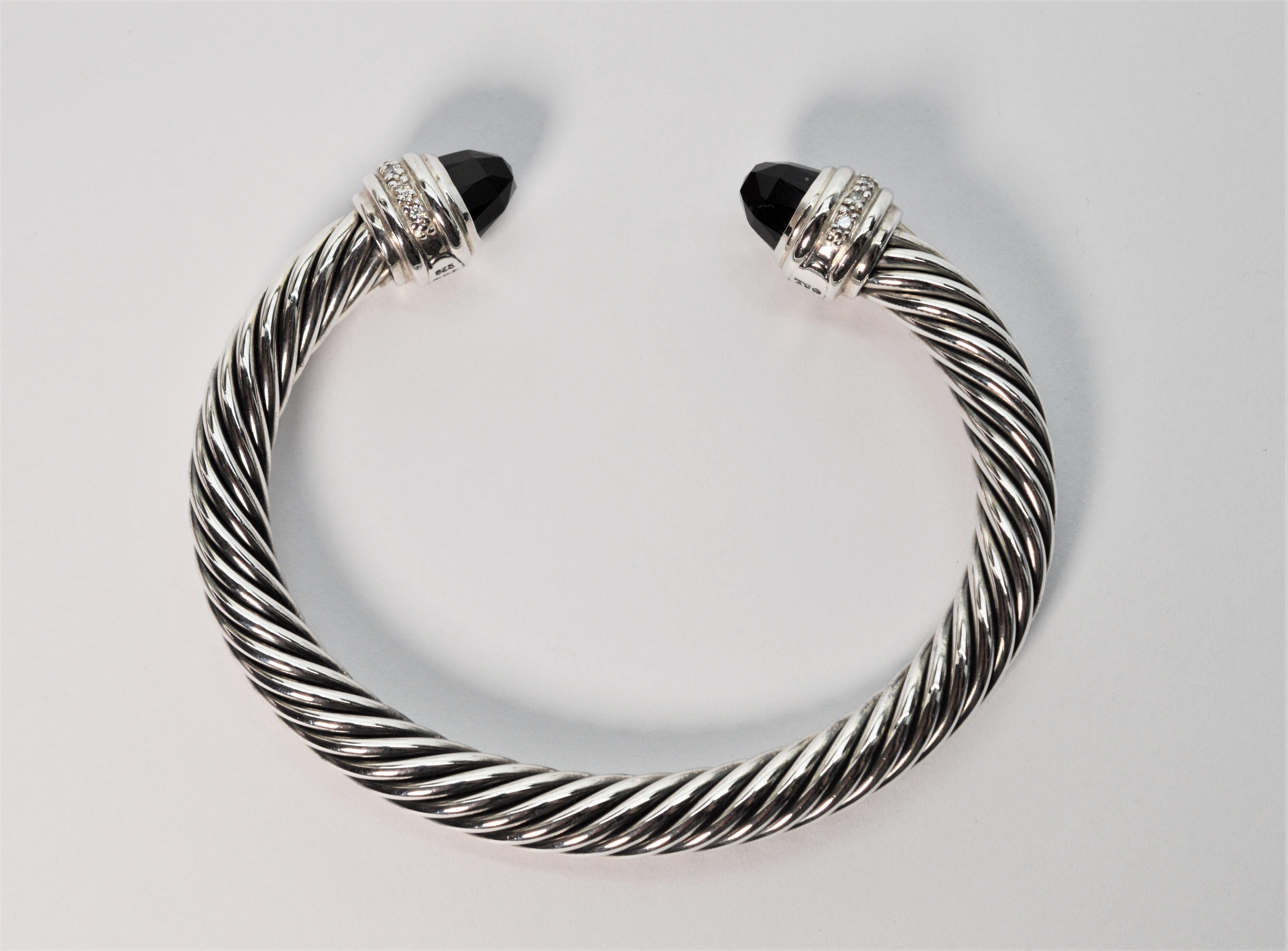 Facet cut black onyx and pave diamonds accent this Cable Classic Sterling Silver Cuff Bracelet by well-known designer David Yurman. This iconic DY bracelet has an overall measurement 
of 2-3/4 x 21/4 inches and is 7mm thick with a 3/4 inch opening.