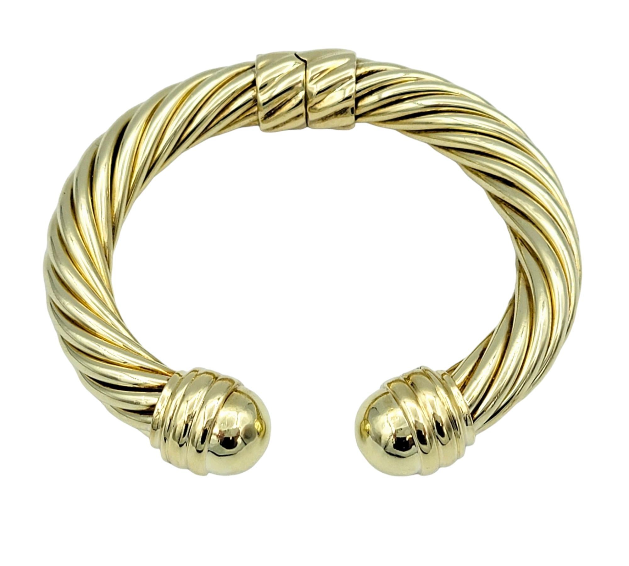 The David Yurman Cable Classics cuff bracelet, crafted in luxurious 14 karat yellow gold, is a timeless and iconic piece of jewelry. Its design features the brand's signature twisted cable motif, showcasing meticulous craftsmanship and attention to