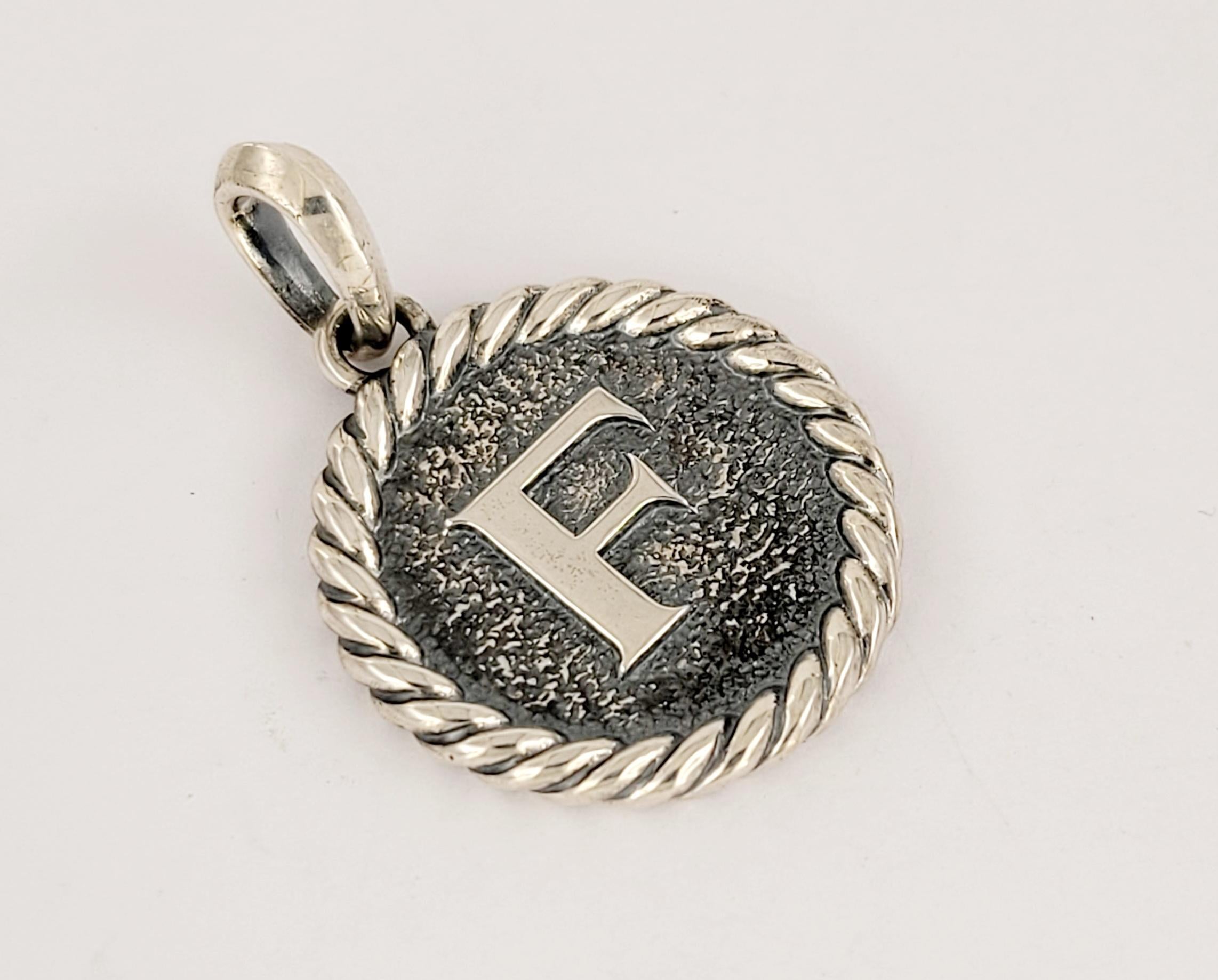 David Yurman Cable Collectibles F Initial Charm Ciondolo Enhancer argento sterling 
Catena con ciondolo
Ciondolo di forma rotonda 24,2 x24,2 mm 
Lunghezza del ciondolo con cappa 36 mm
Lunghezza della catena 18,5''
Catena regolabile 17,5''