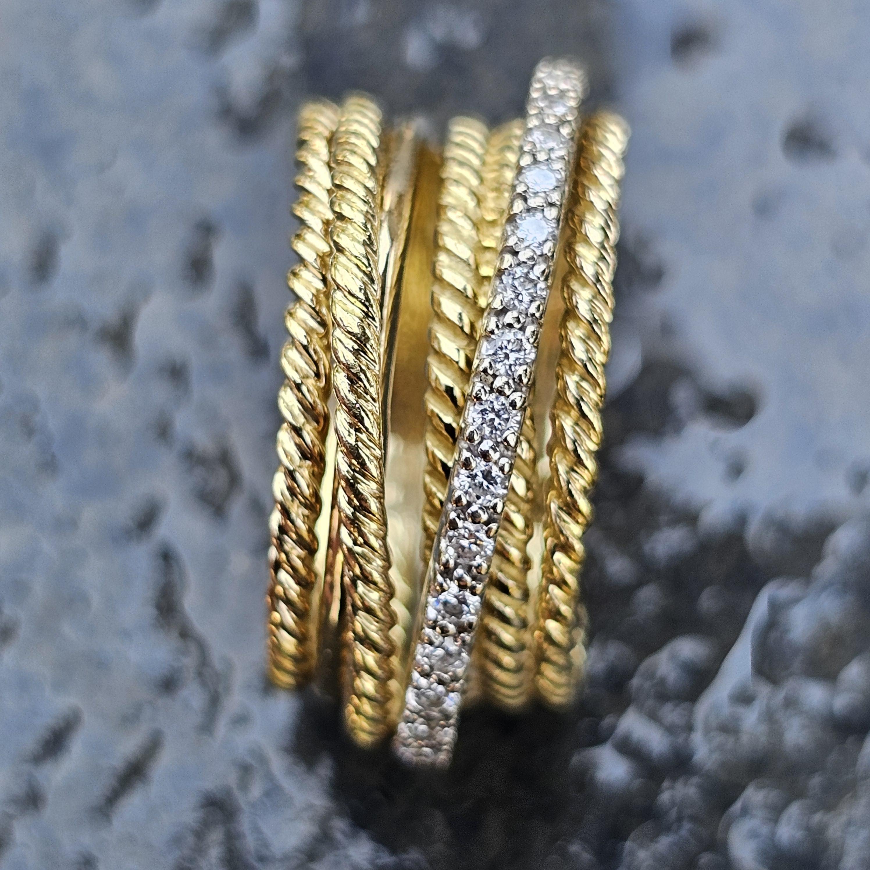Dieser Ring von David Yurman ist aus 18-karätigem Gold gefertigt und zeigt ein Multi-Band-Design. Der Ring hat die Größe 6,75 und besticht durch die Kombination von gedrehten Goldbändern und einem mit Diamanten besetzten Band. Die Diamanten sind