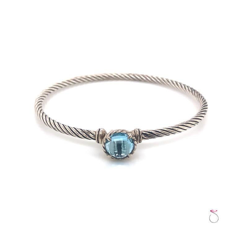David Yurman Chateline cable bracelet with blue Topaz in sterling silver. This bracelet is beautifully crafted in a cable design in sterling silver. The Beacelet is set with a 7.35 mm faceted round blue Topaz. The Topas is set in four prongs and