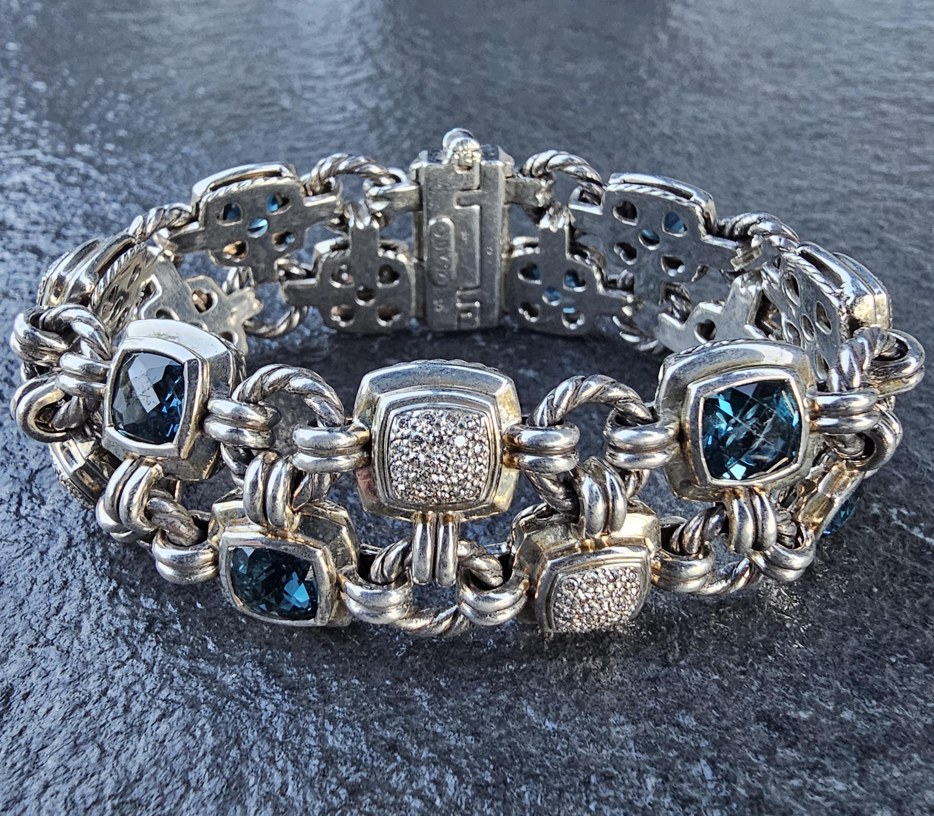 Esta exquisita pulsera Chiclet de David Yurman es una pieza refinada para cualquier entusiasta de la joyería. Fabricado en plata de ley, presenta un diseño único con piedras de topacio azul talla cojín y diamantes redondos en pavé que añaden un