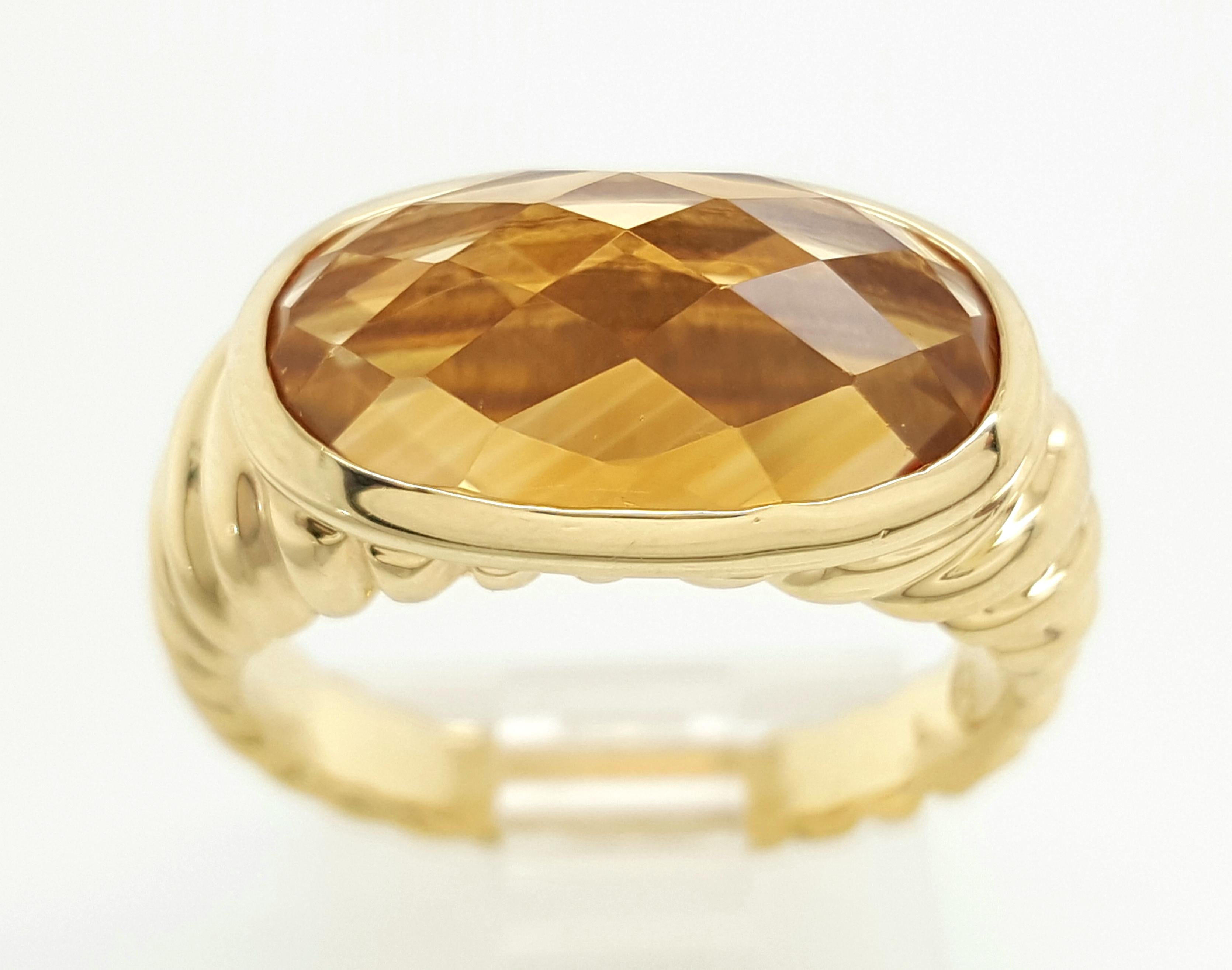 David Yurman Citrine Noblesse 18 Karat Yellow Gold Ring is a beautiful retired signature piece. The classic cable ring tapers from a 9.5mm to a 3.26mm on the back of the shank holding a brilliant, orange, oval citrine center bezel set in the center.