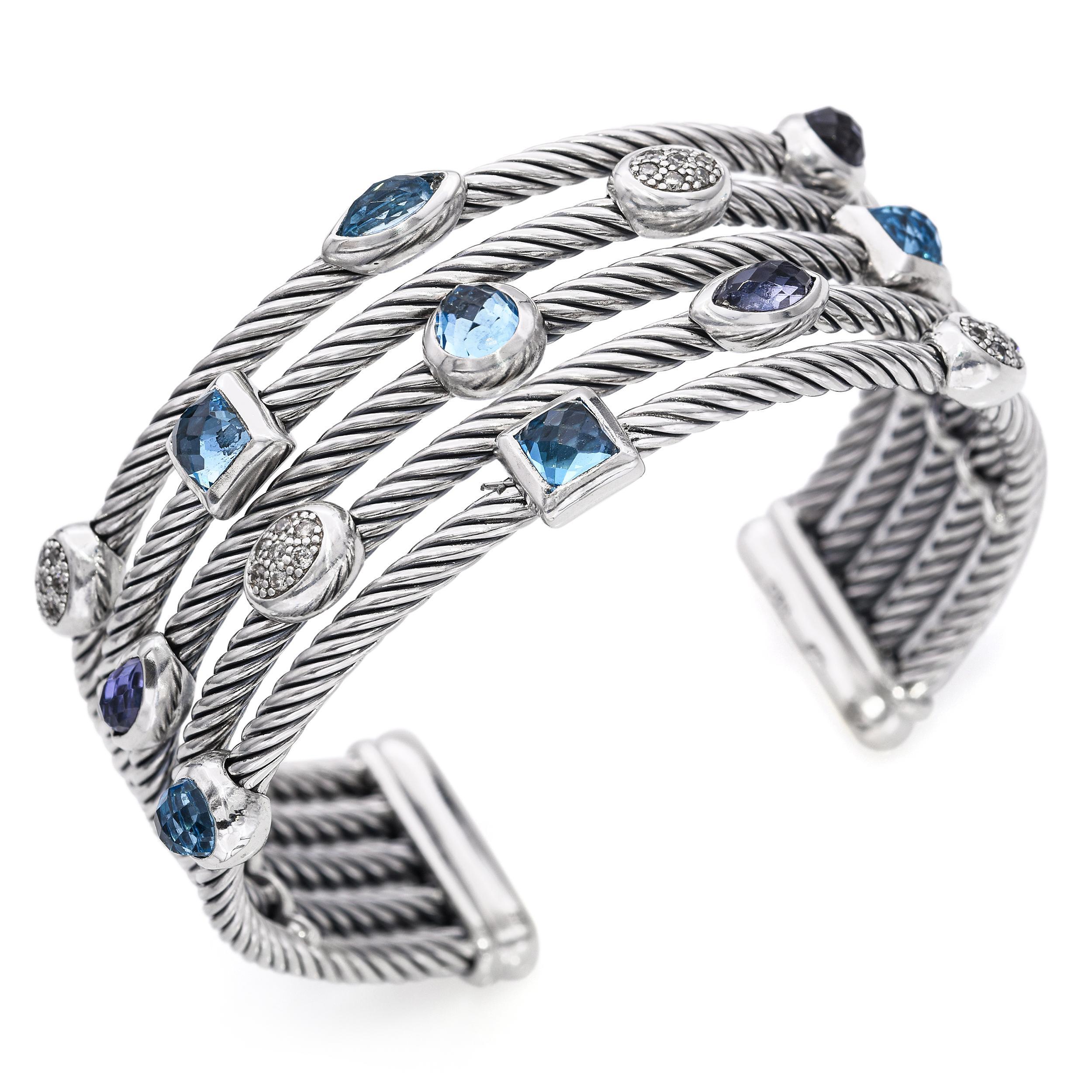 This vibrant David Yurman Confetti cuff bracelet features a three-row design composed of twisted sterling silver cable. Bezel-set gemstones—blue topaz, iolite, and turquoise—are scattered throughout the cuff, accented by sparkling diamonds for a