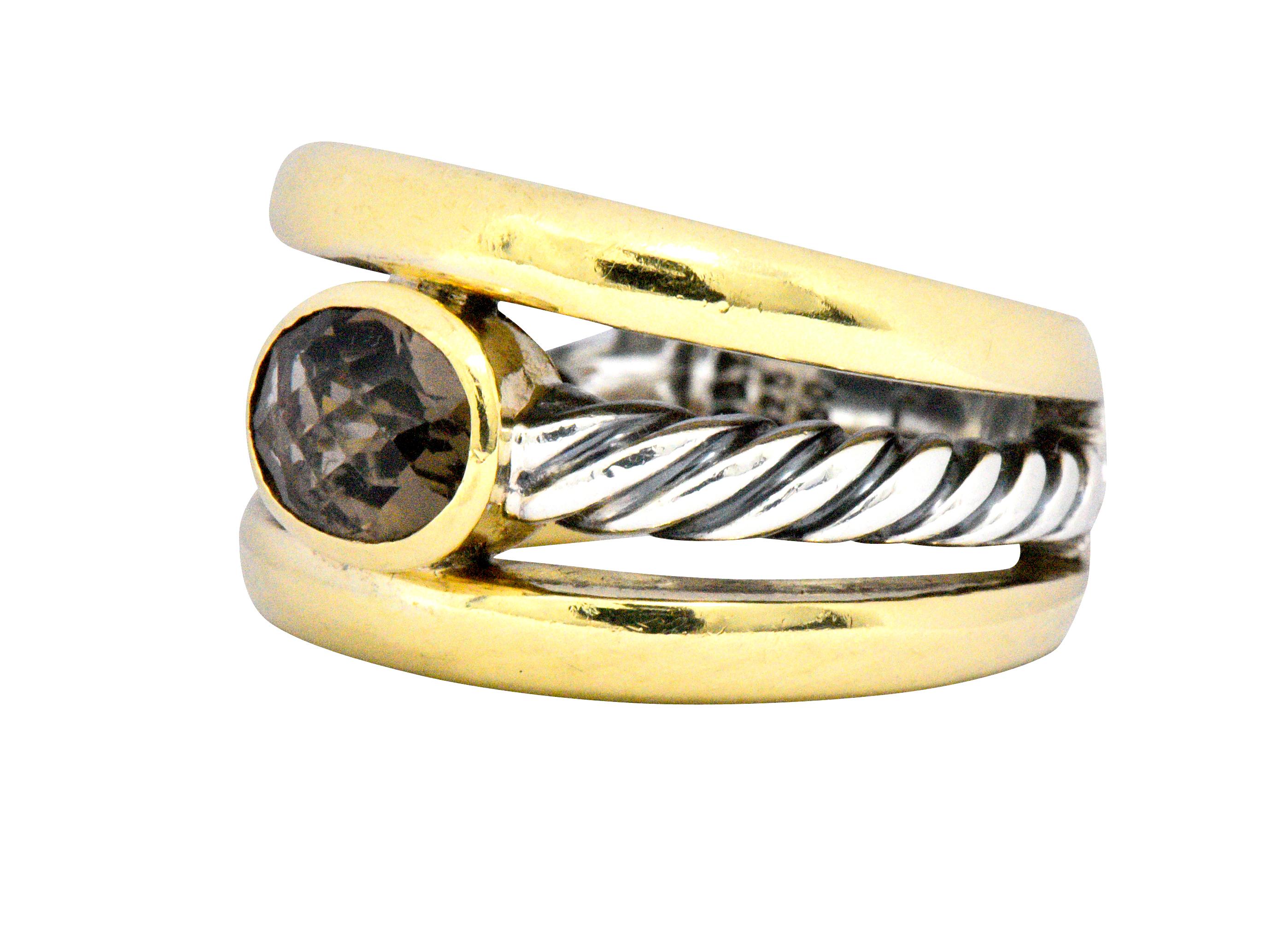 Centering a bezel set oval checkerboard cut smoky quartz measuring approximately 7.6 x 5.8 x 3.8 mm
With twisted sterling sliver and polished gold details
Signed D.Y.
Ring Size: 7 1/4 & Sizable
The top of the ring measures 13.2 mm wide and the ring