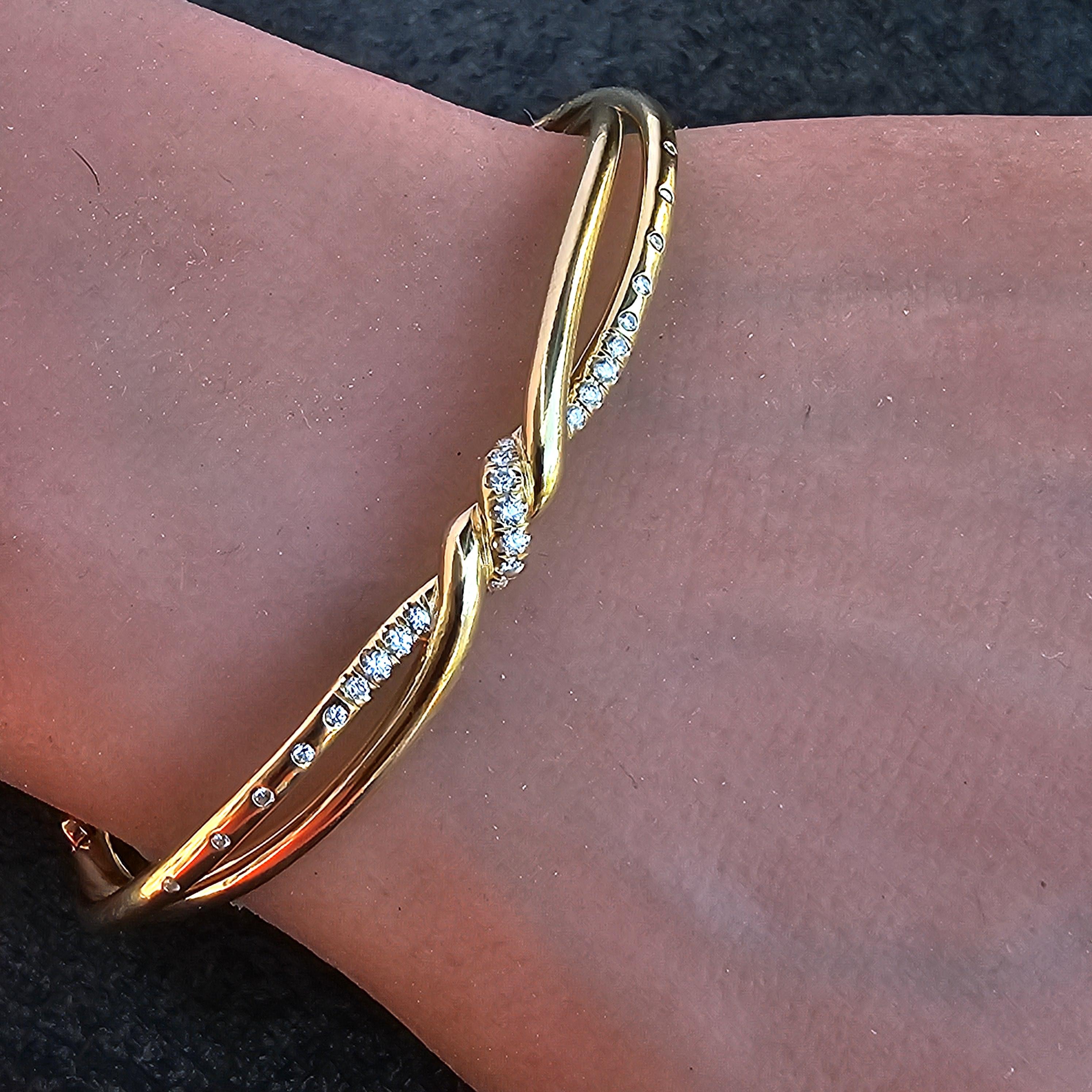 Esta es una pulsera brazalete de diamantes David Yurman Continuance Center Twist de oro amarillo de 18 quilates. El diseño presenta un elegante giro adornado con diamantes blancos, que crean un llamativo contraste con el oro. Esta pieza es un