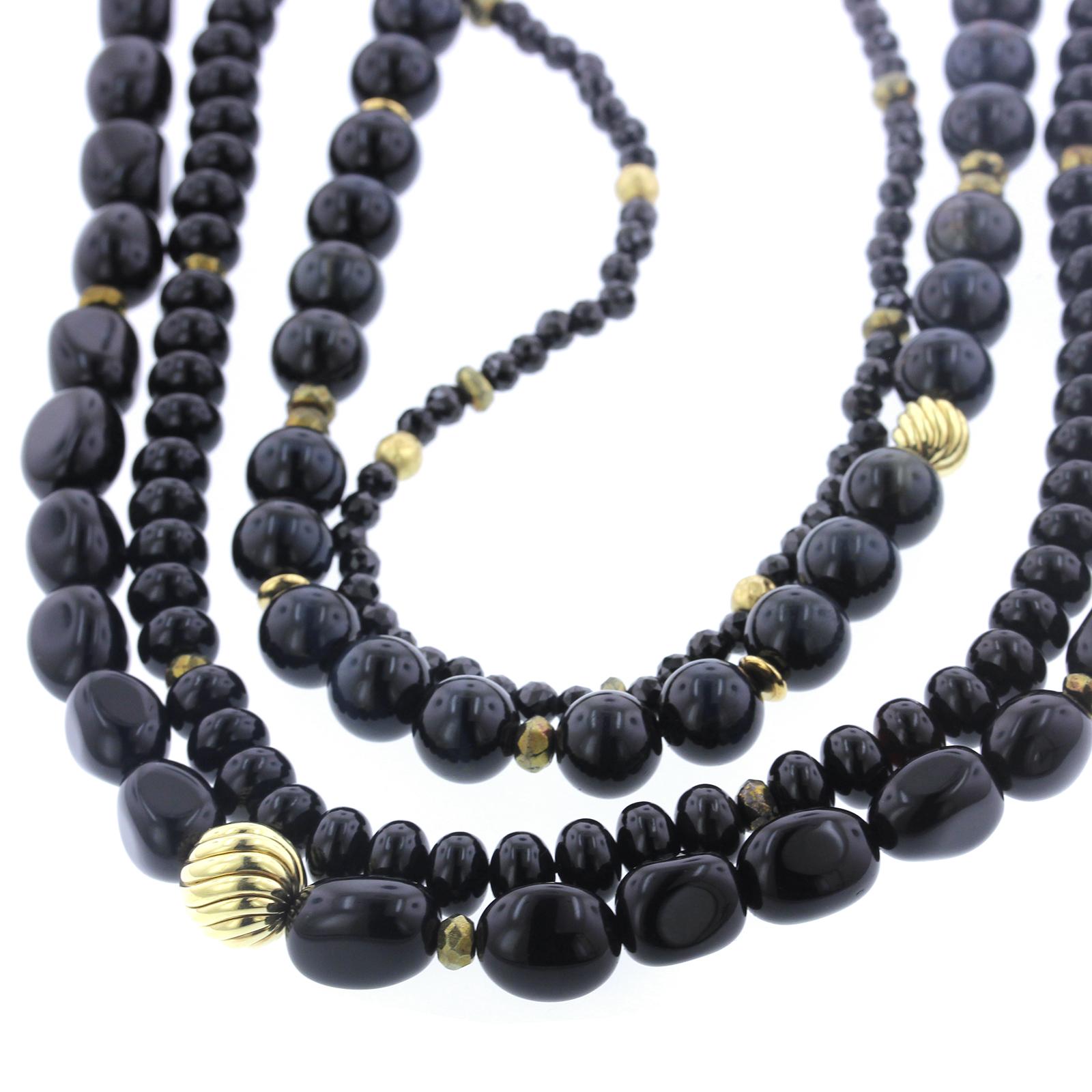 David Yurman Couture 18K Yellow Gold Black Onyx and Obsidian Bead Necklace. The
necklace is designed with four strands of various shaped beads, completed by
an 18K gold clasp, length 18-24