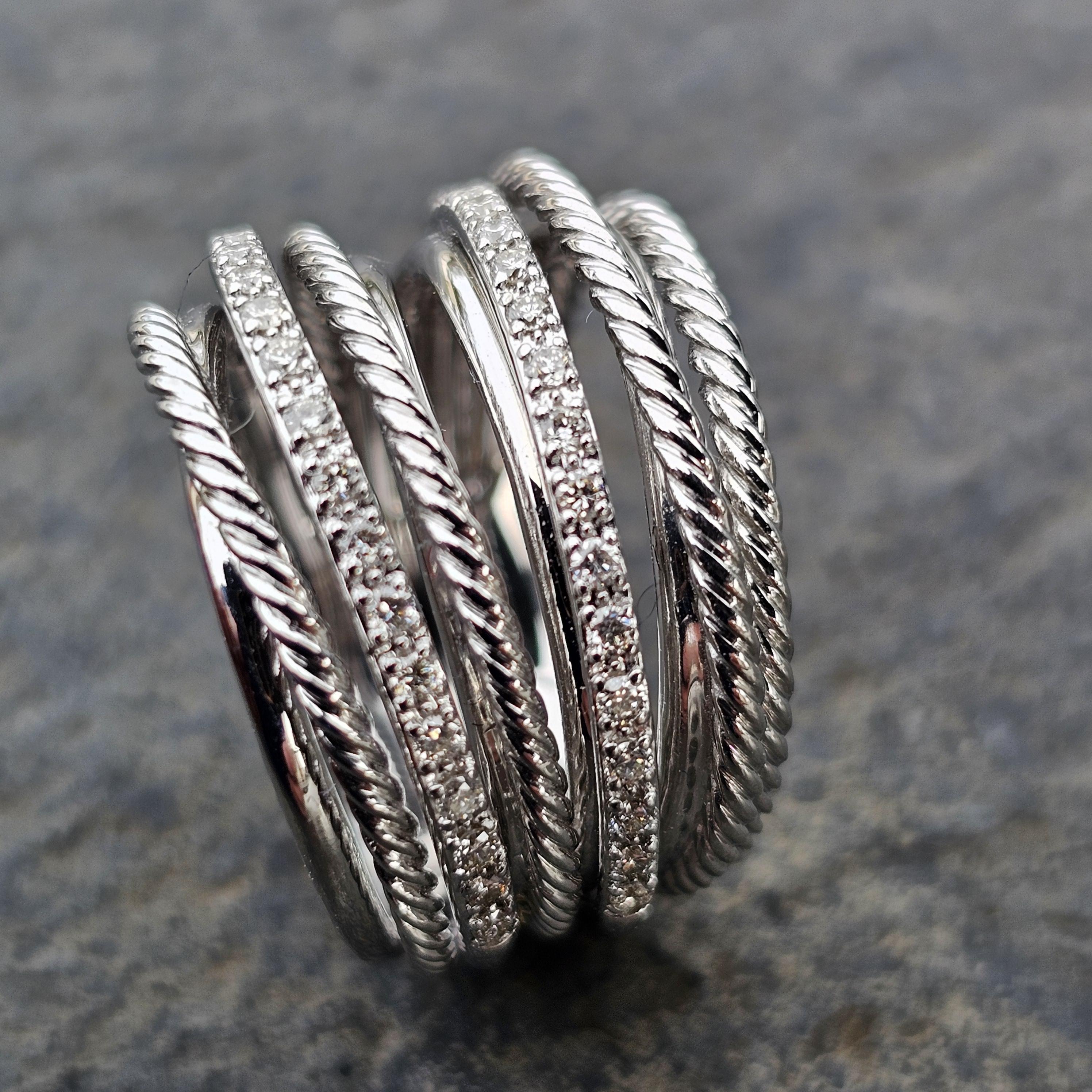 Here we have a David Yurman wide crossover sterling silver band ring with 0.33ct white diamonds, size 7.
The intricate design features twisted rope details and sparkling diamond accents, creating a striking visual effect.
Retail price is currently