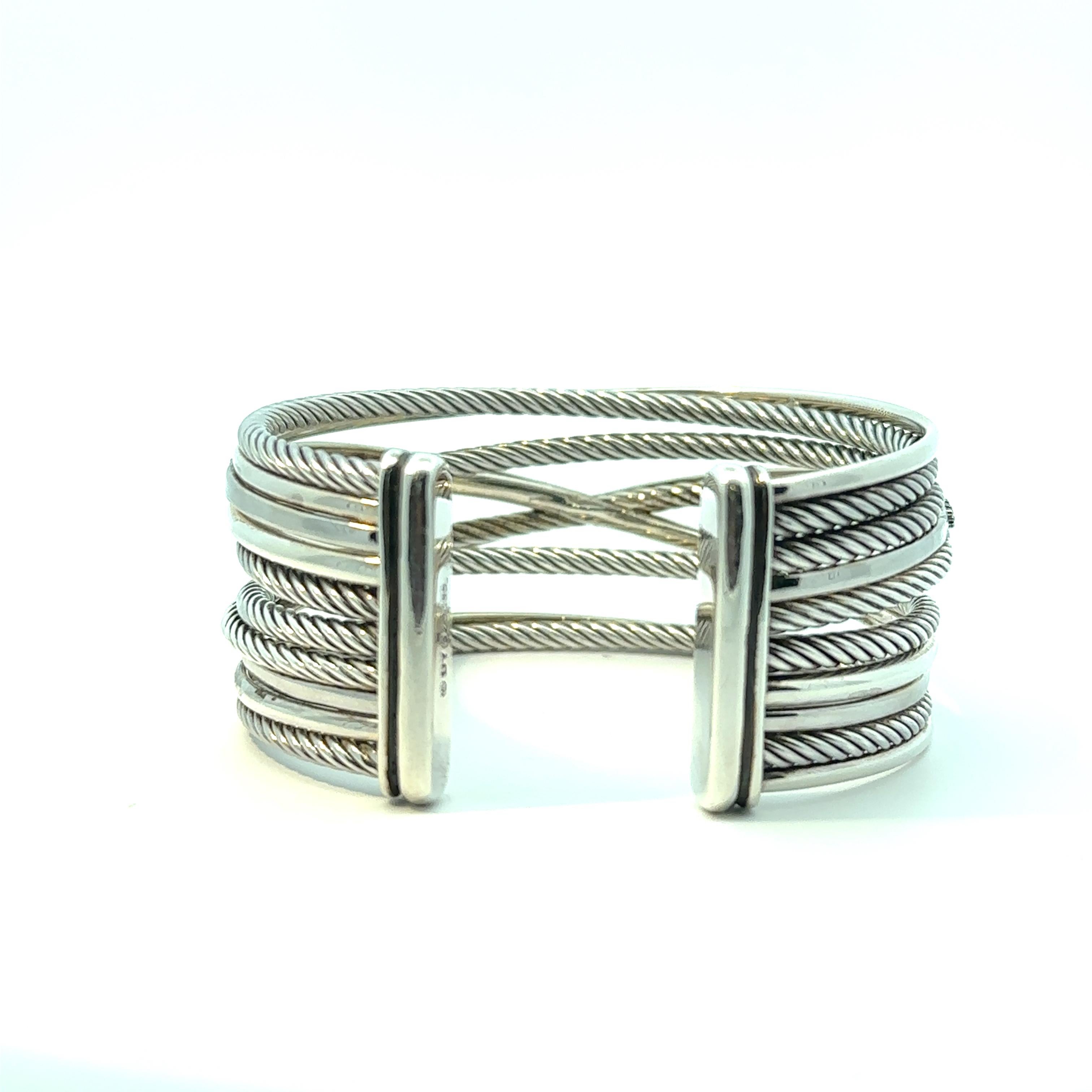 La pulsera brazalete David Yurman presenta un elegante diseño elaborado en plata de ley y oro blanco de 14 quilates. Adornada con deslumbrantes diamantes y llamativos diamantes negros, esta pulsera tiene un encanto sofisticado. Mide 7 pulgadas de