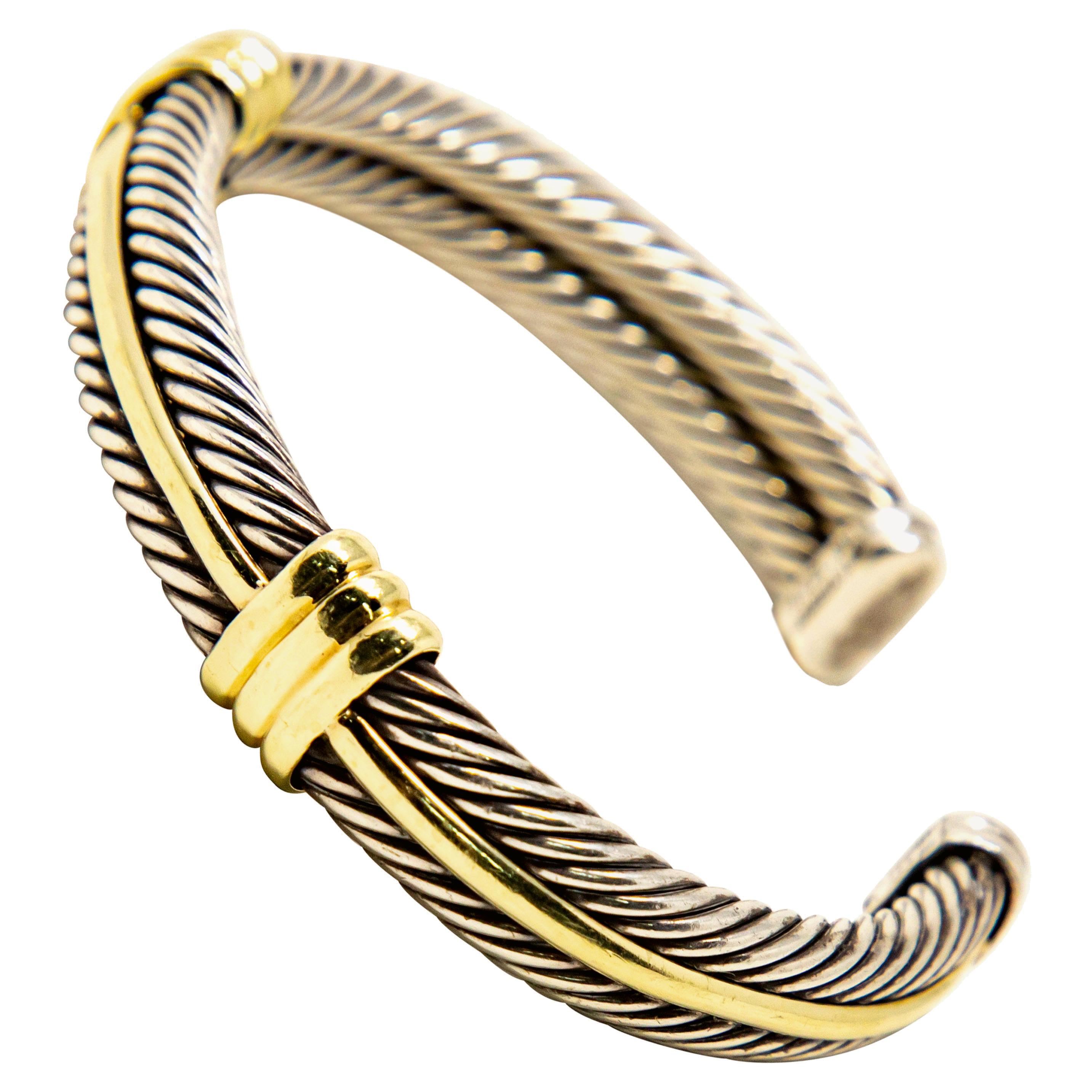Offering this impeccable David Yurman cuff bracelet. Made of sterling silver that has been twisted, and 14-karat gold accenting this gorgeous bracelet. Cuff is marked, © D. YURMAN, 14K, 925.