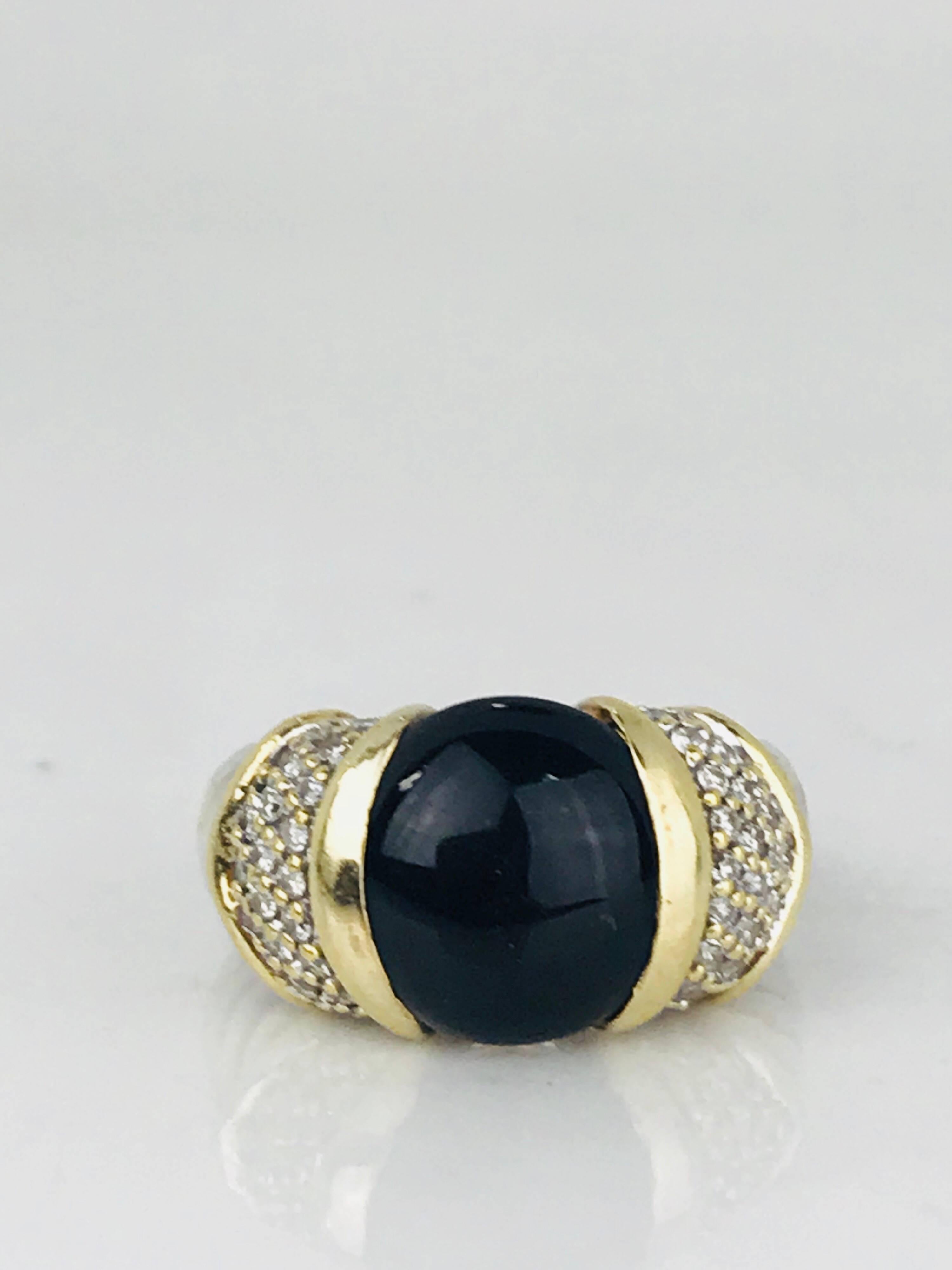 Contemporary David Yurman ring features a round polished black onyx stone, bar-set in 18 karat gold, flanked on both sides with (44) round brilliant pave set diamonds on a sterling silver signature cable-style band.

Black onyx stone measures 12.10