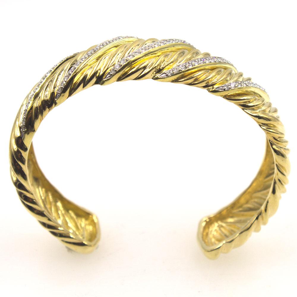 Fashionable diamond cuff bracelet by David Yurman. The bracelet is fashioned in textured 18 karat yellow gold and features 5 rows of 75 round brilliant cut diamonds that equal approximately  .75 carat total weight. The cuff measures 7.5 inches in