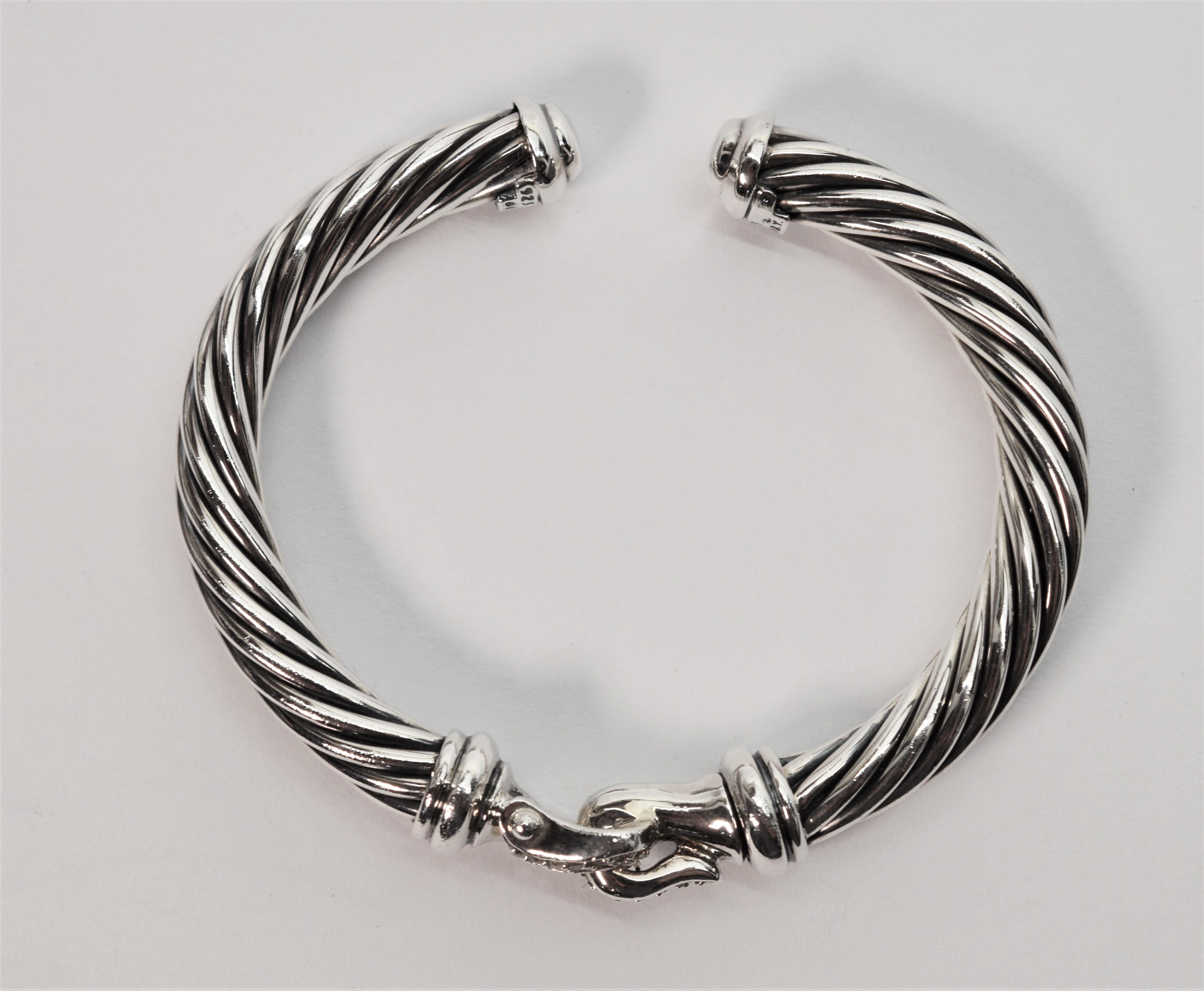 Prong set diamonds sparkle on the buckle featured on this Cable Classic Sterling Silver Cuff Bracelet by well-known designer David Yurman. With .18 carat diamonds total weight, this timeless DY bracelet has an overall measurement of 2-1/2 x 21/4