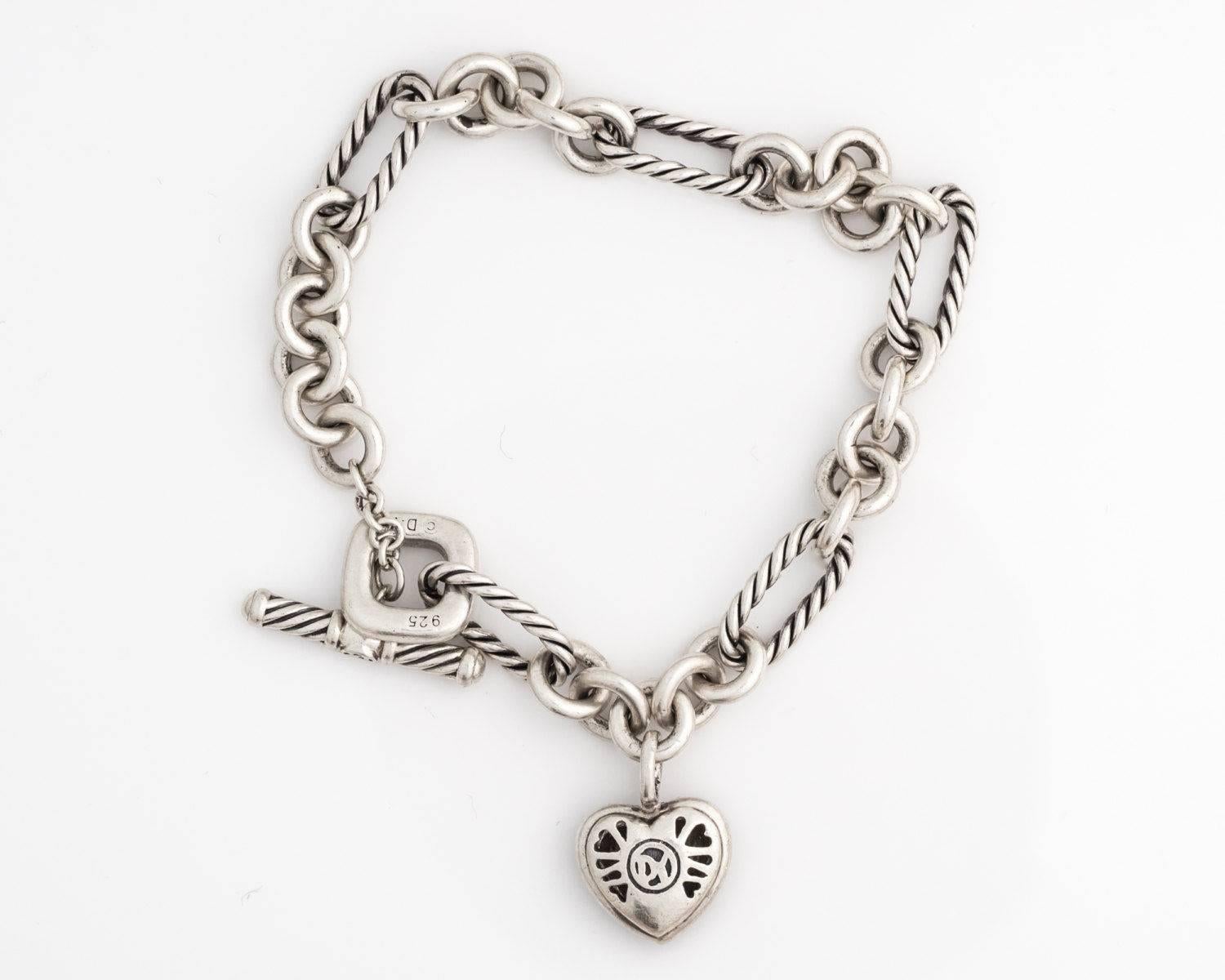 David Yurman Cable Diamond Heart Charm Toggle Bracelet in Sterling Silver

Features a Sterling Silver puffed cable heart framed by a Diamond Halo. The puffed back of the charm has heart shaped cut outs. The bracelet alternates Sterling Silver oval
