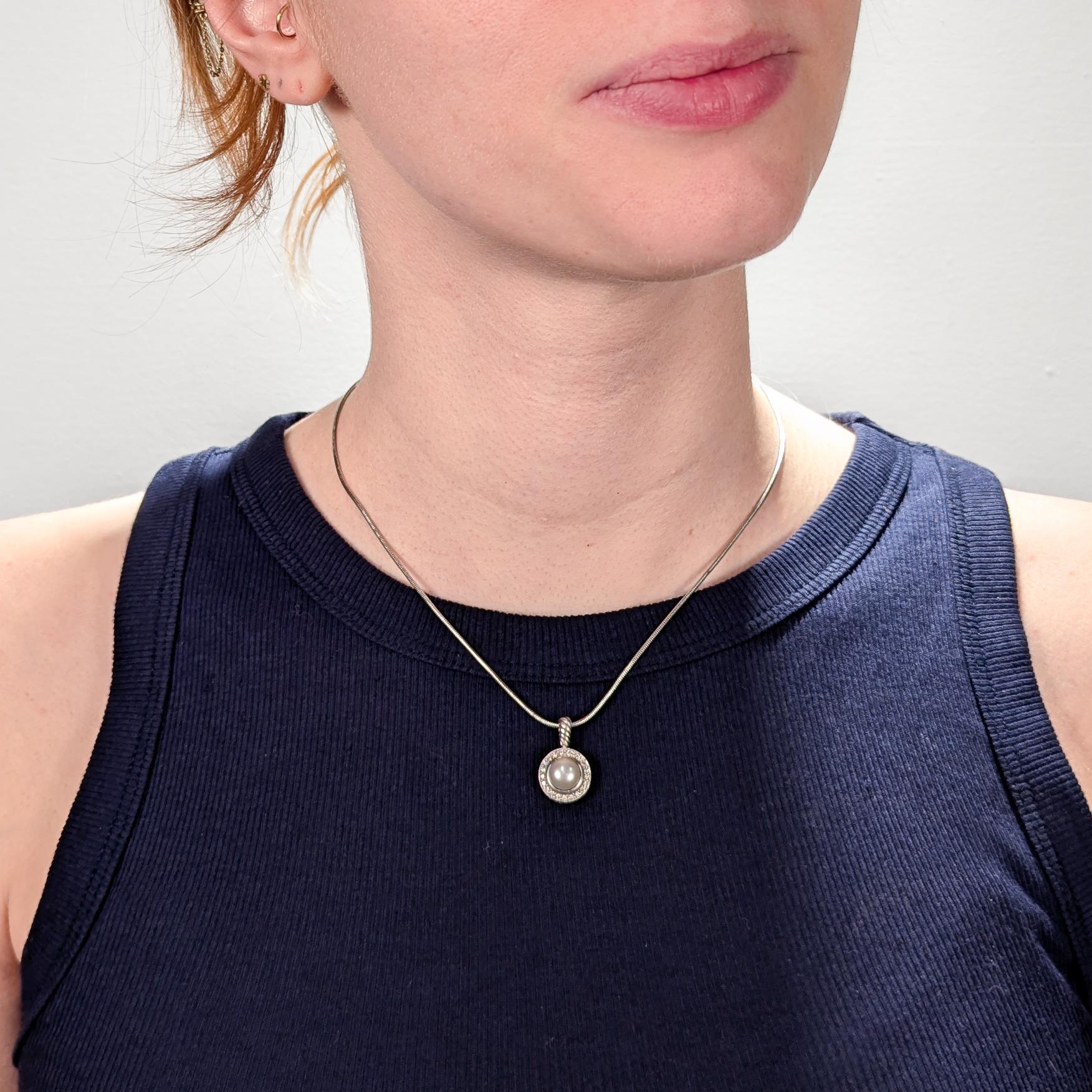 A fine designer sterling silver, pearl, and diamond pendant.

By David Yurman.

In sterling silver.

From the Cerise collection.

With a central bezel-set pearl surrounded by a halo of 21 round cut diamonds.

Marked to the reverse with DY / 925 /