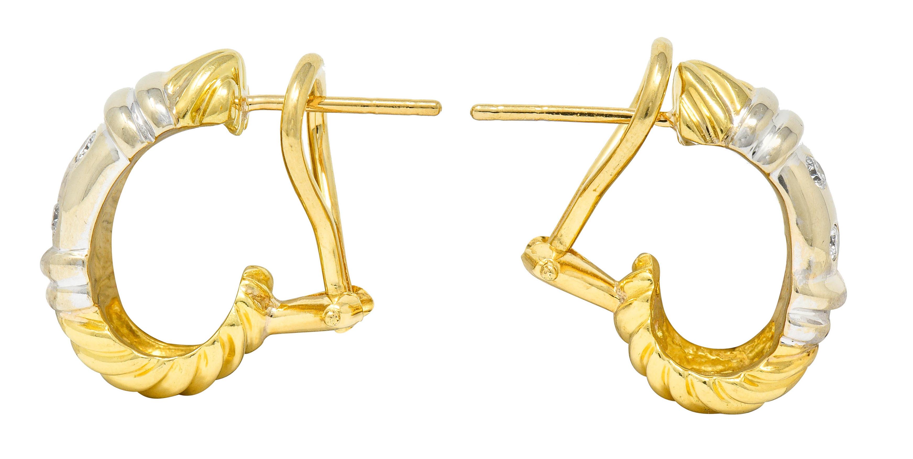 J hoop earrings comprised of yellow gold twisted cable motif and a ribbed sterling silver station

Flush set with round brilliant cut diamonds weighing approximately 0.16 carat; eye-clean and white

Completed by posts and hinged omega backs

Signed
