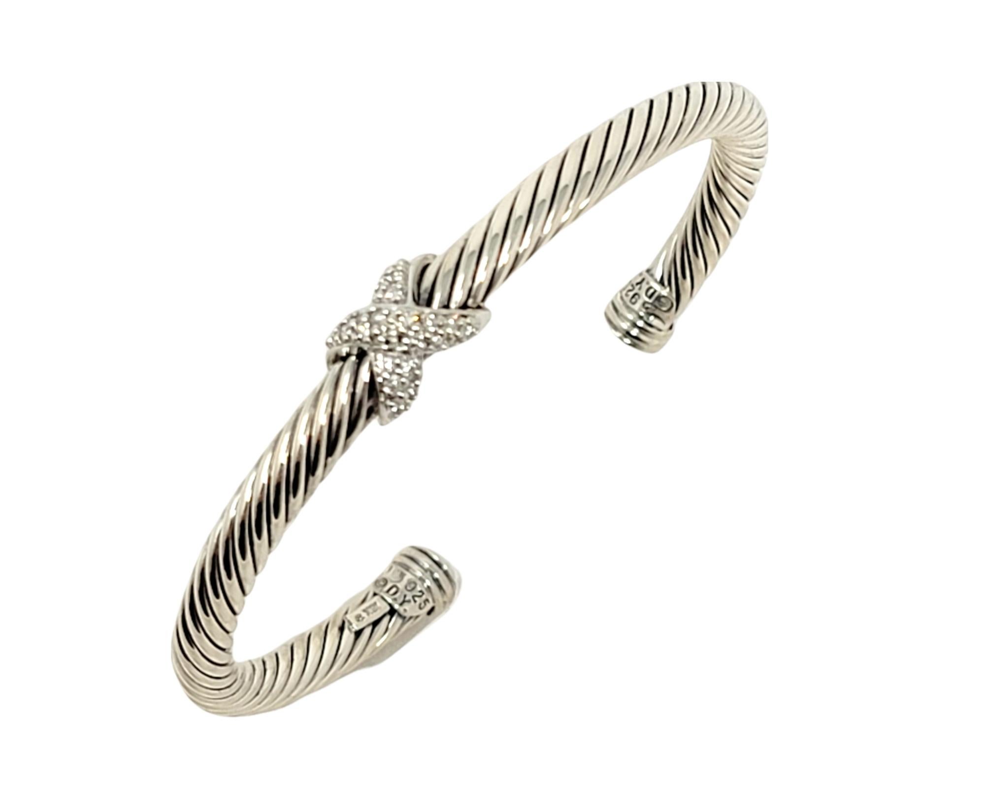 Beautiful contemporary cable bangle bracelet by jewelry designer, David Yurman. It features his signature twisted cable design in sterling silver accented by a diamond embellished 'X' at the center.  

Metal: Sterling Silver
Natural Diamonds: .14