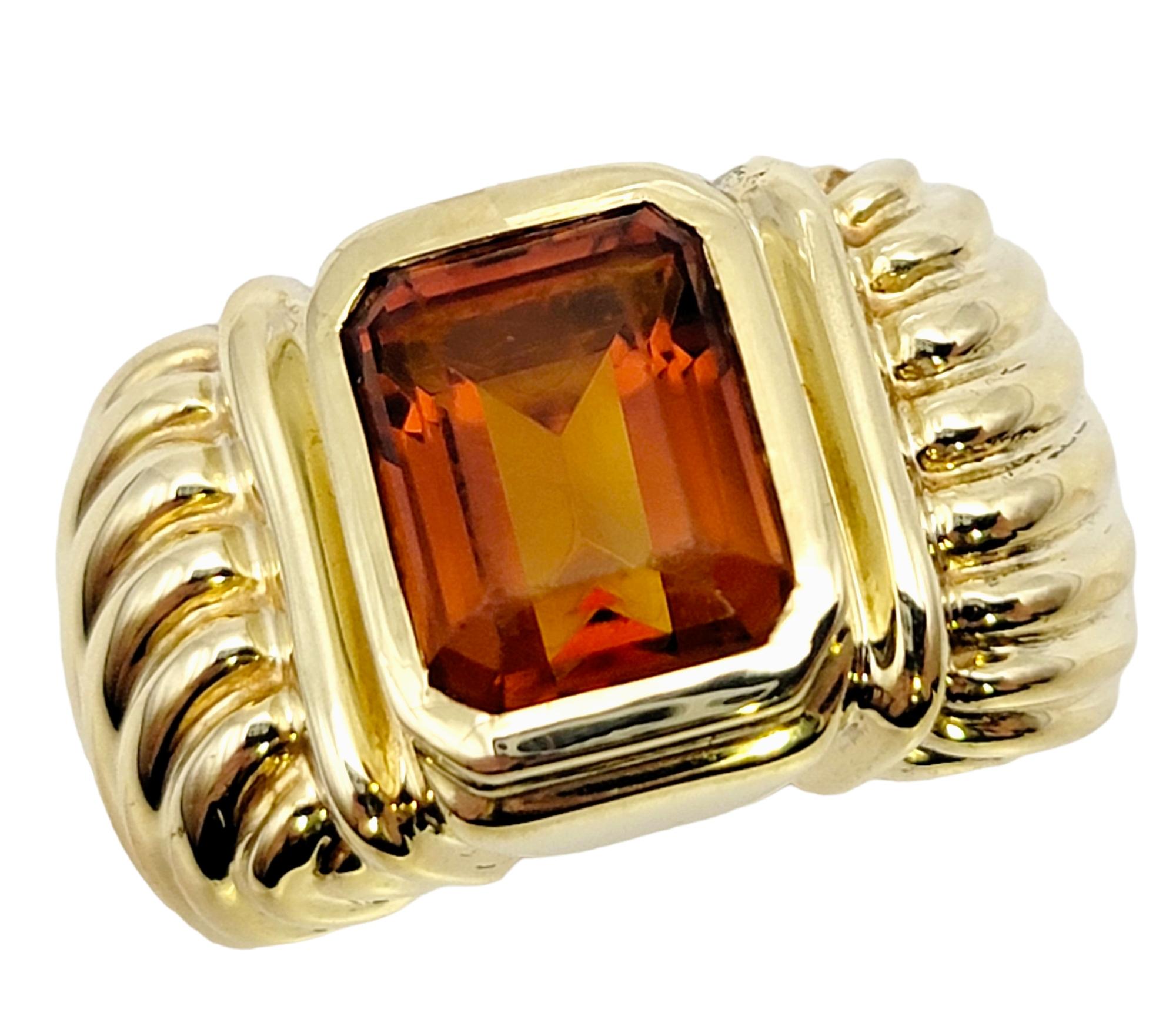 Ringgröße: 6.5

Hübscher Designer-Cocktailring des geschätzten Juweliers David Yurman. Dieses zeitgenössische Schmuckstück setzt mit seinem kühnen gelb-orangen Citrin im Smaragdschliff und der breiten, geriffelten Fassung aus Gelbgold einen