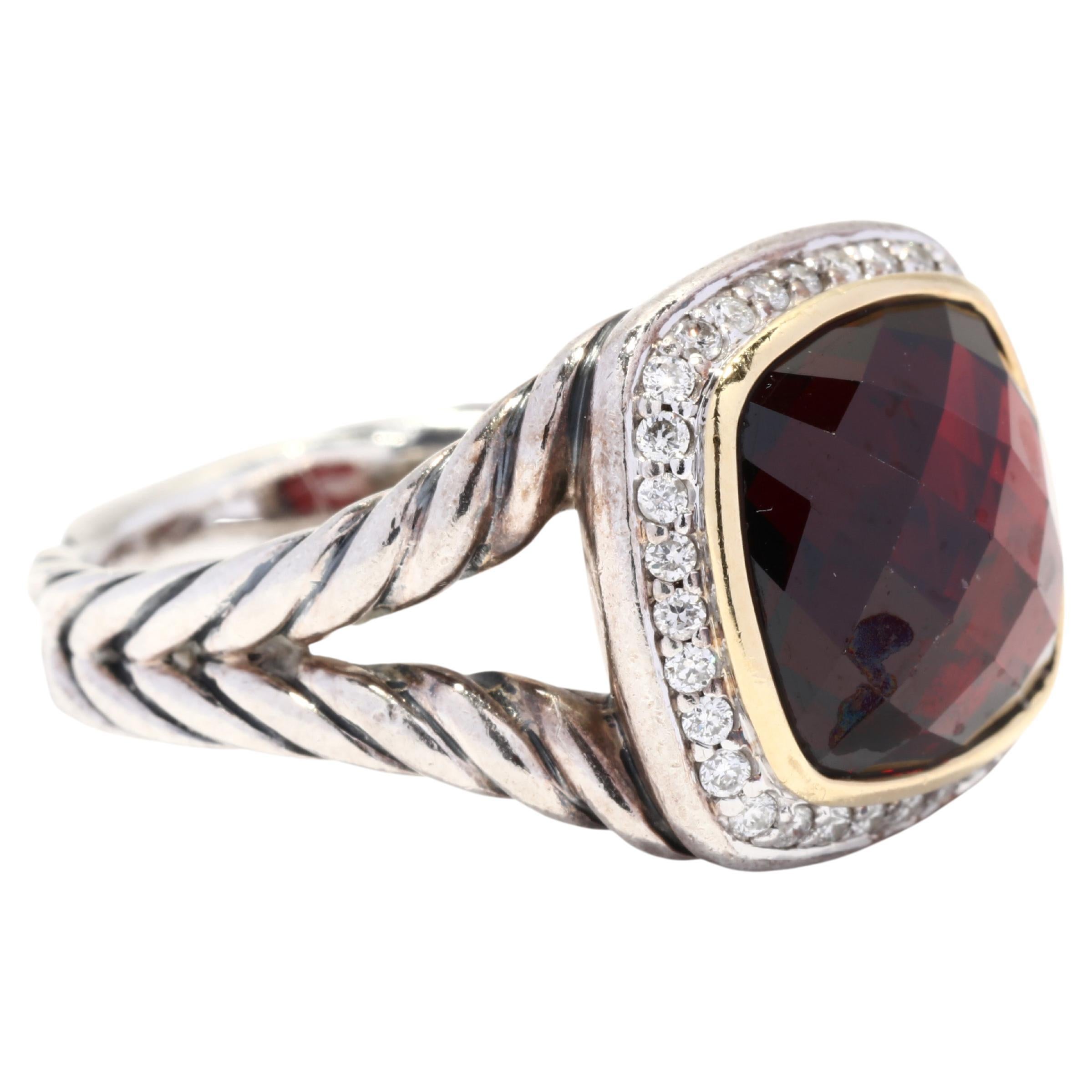 A vintage 18 karat yellow gold, sterling silver, garnet and diamond Albion ring designed by David Yurman. This medium size ring features a bezel set, checkerboard cushion cut garnet center stone surrounded by a halo of full cut round diamonds