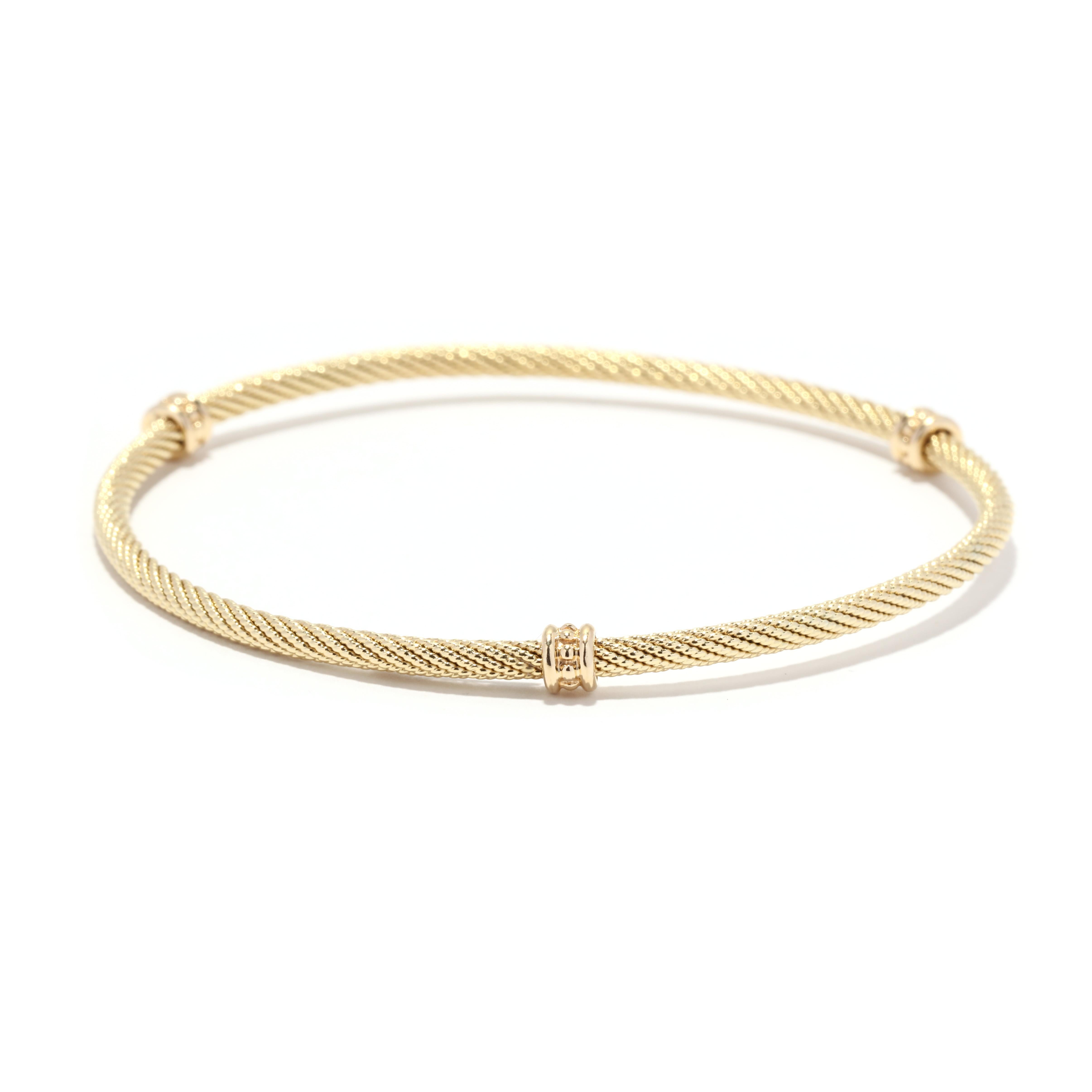 A vintage David Yurman 18 karat yellow gold bangle bracelet. This stackable bangle features a textured cable twist eternity design with three beaded stations throughout.

Circumference: 7.25 in.

Width: 4.65 mm

Weight: 4.9 dwts. / 7.6