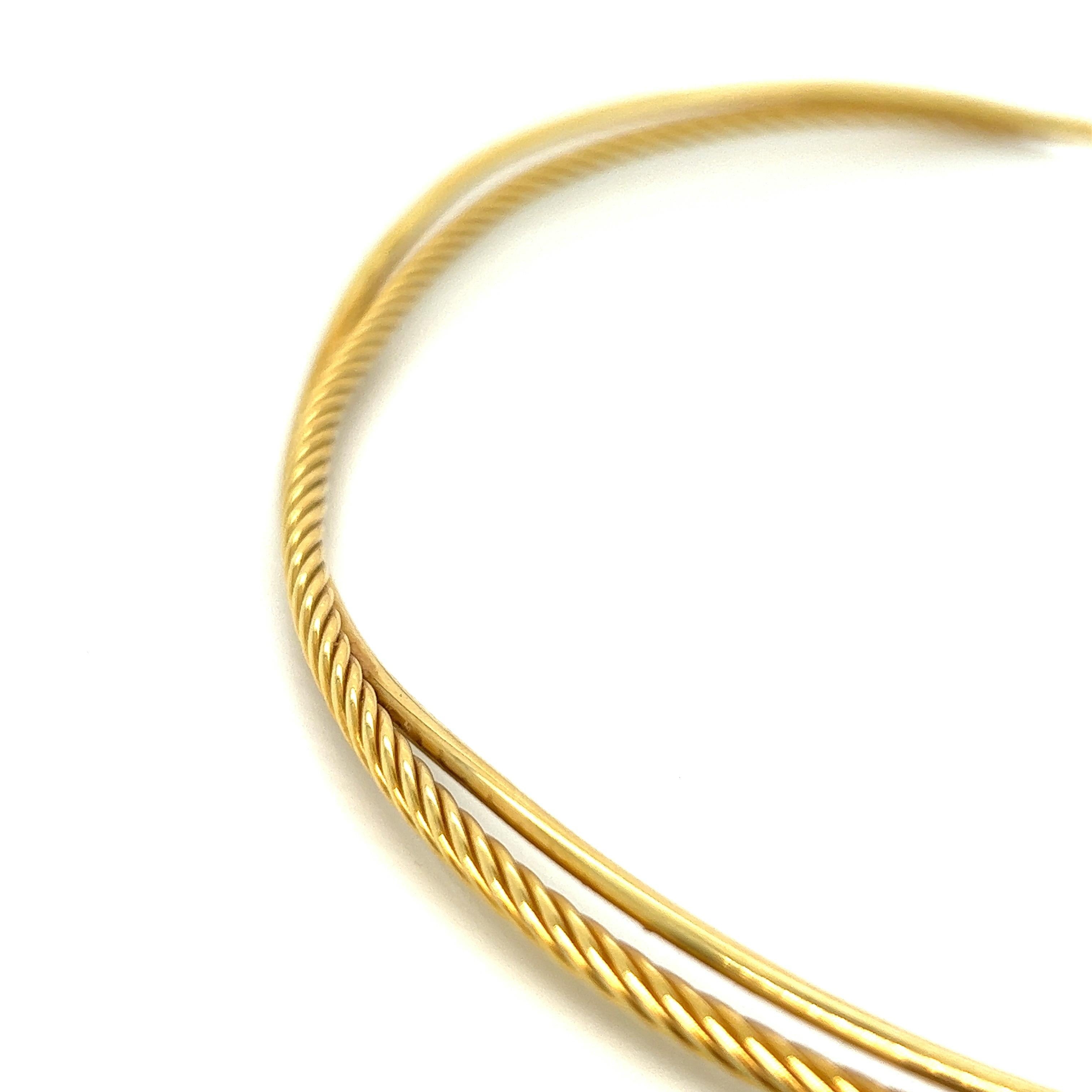 David Yurman gold collar necklace 

Twisted strand wrapped by another untwisted strand, 18 karat yellow gold; marked DY, 750

Inner circumference: 14.25 inches
Total weight: 22.3 grams