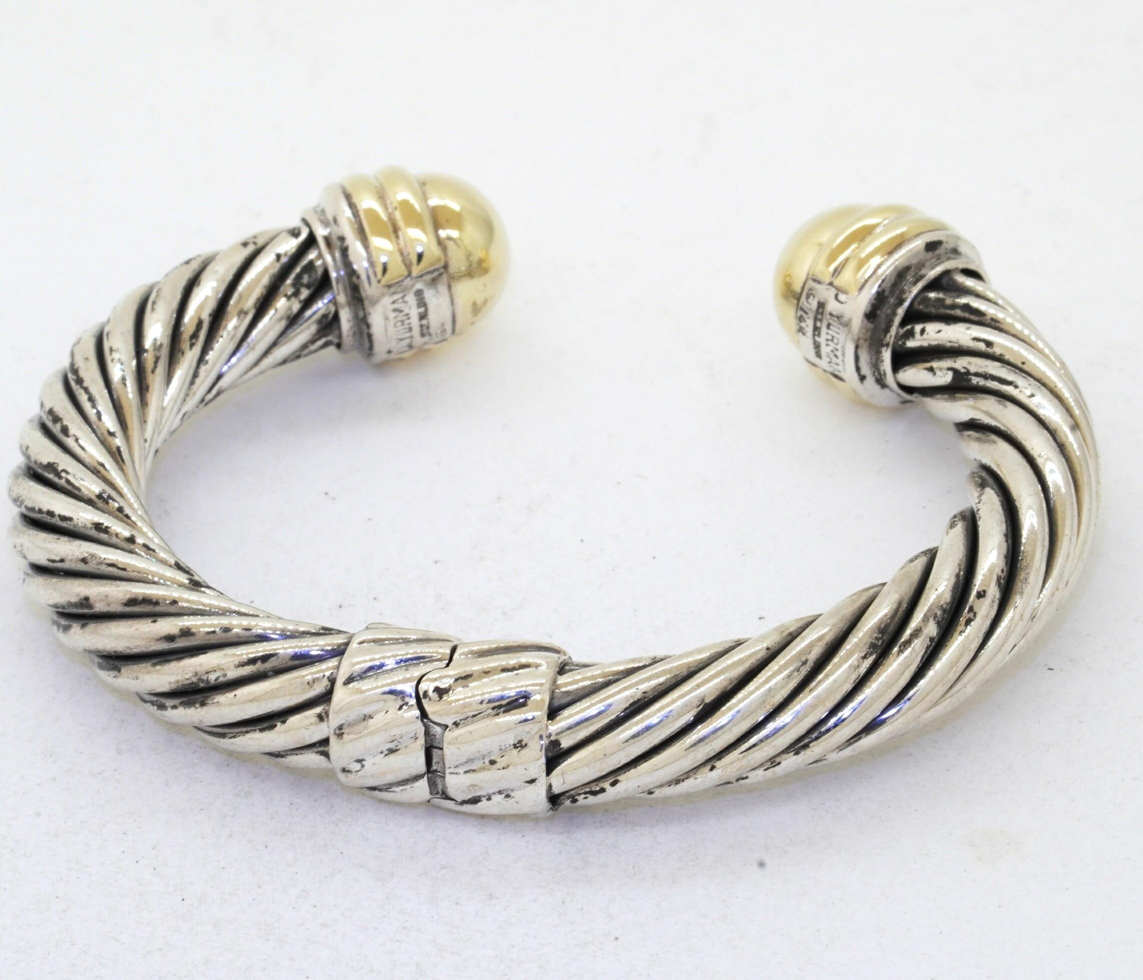 David Yurman heavy 14K YG & 925 Sterling silver cuff bracelet. This fashionable piece of jewelry is crafted in both gorgeous 925 Sterling silver & 14K yellow gold and features a beautiful 9.4mm wide cable cuff bracelet. This bracelet is spring