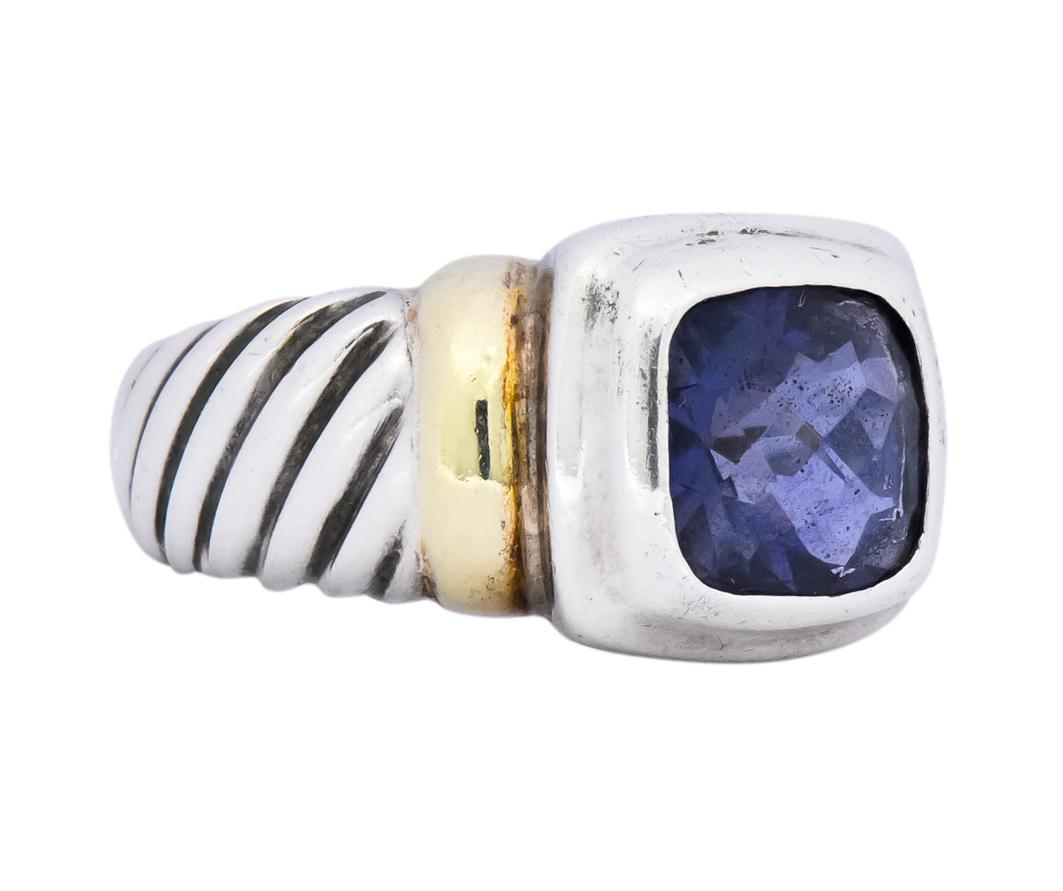 Centering a cushion checkerboard cut iolite measuring approximately 8.0 x 8.0 mm, transparent medium-dark grayish-violet in color

Bezel set in sterling silver surround flanked by gold bar shoulders

With twisted cable motif shank

From David