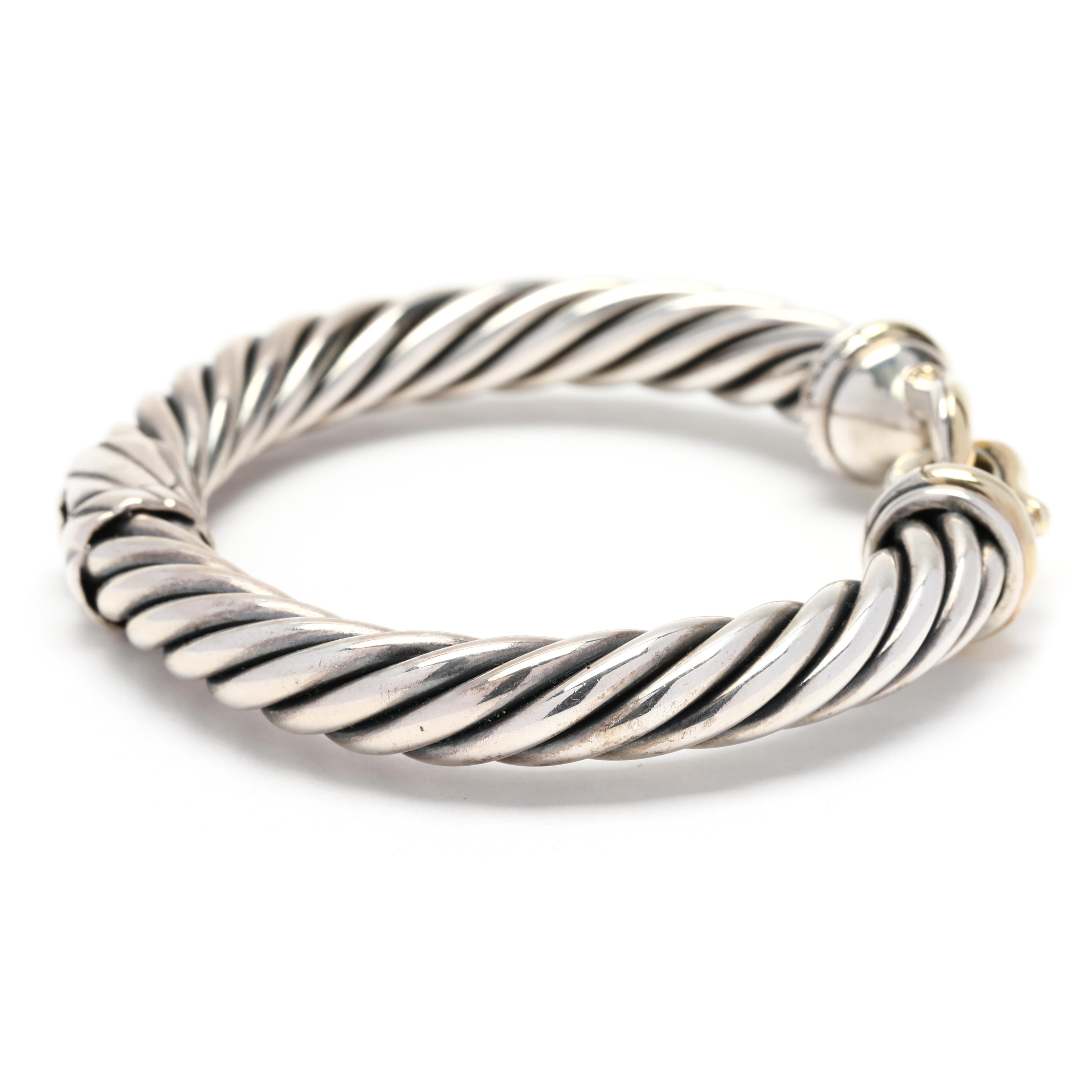 This stunning David Yurman Large Buckle Cable Bracelet is sculpted from 14K yellow gold and sterling silver. With its signature intricate cable design and exquisite buckle clasp, this bracelet adds a luxurious touch to any outfit. Its generous