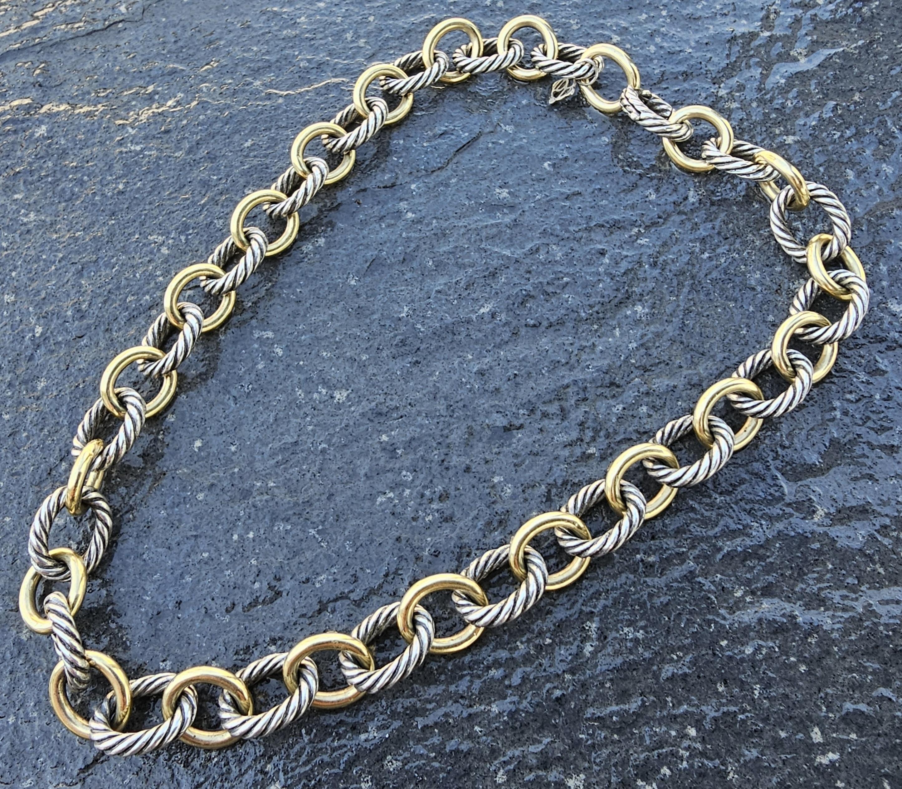 Este exquisito collar de cadena es una pieza impresionante para cualquier aficionado a la joyería. Fabricado por David Yurman, presenta un sofisticado diseño con eslabones alternados de oro de 18 quilates (1/4) y plata de ley, creando un llamativo
