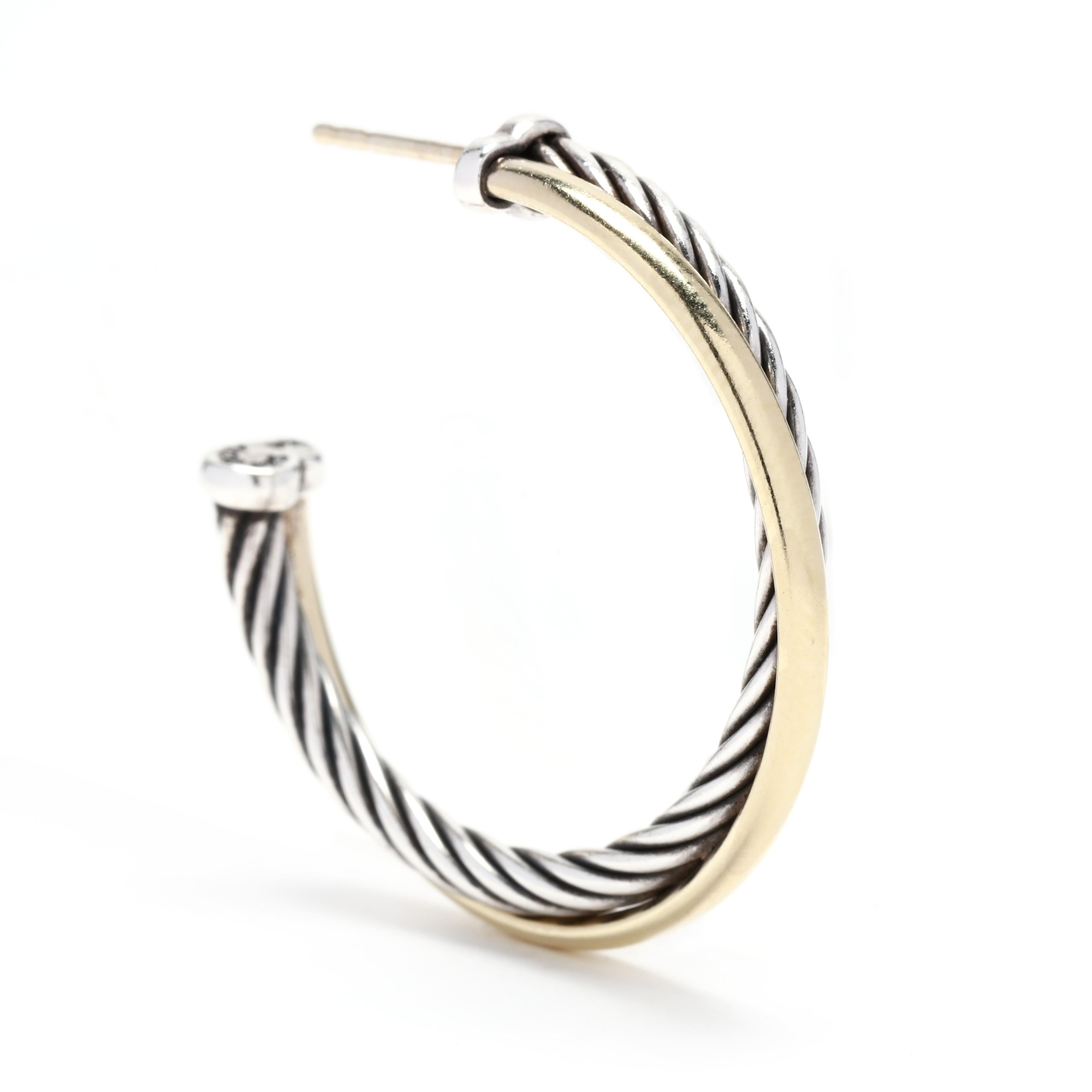 A pair of 14 karat yellow gold and sterling silver medium crossover hoop earrings by David Yurman. These earrings feature a silver cable motif hoop with a flat polished hoop that crosses over and with post and push backs.



Length: 1.25
