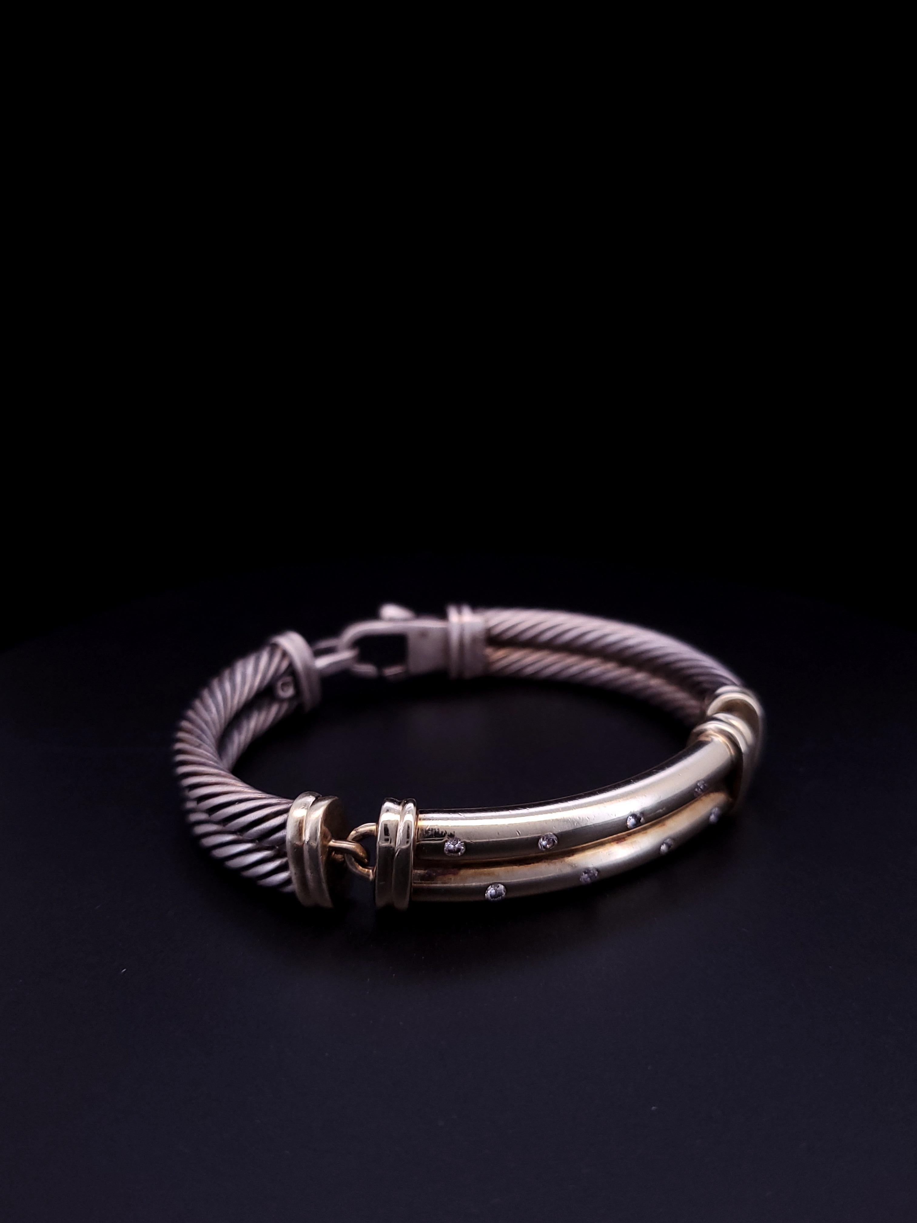 This is an authentic DAVID YURMAN Sterling Silver 14K Yellow Gold Diamond 10mm Metro Double Cable Bracelet. This bracelet is sterling silver with two rows of signature 5mm cables and features a 14 karat yellow gold bar lined with pave diamonds of