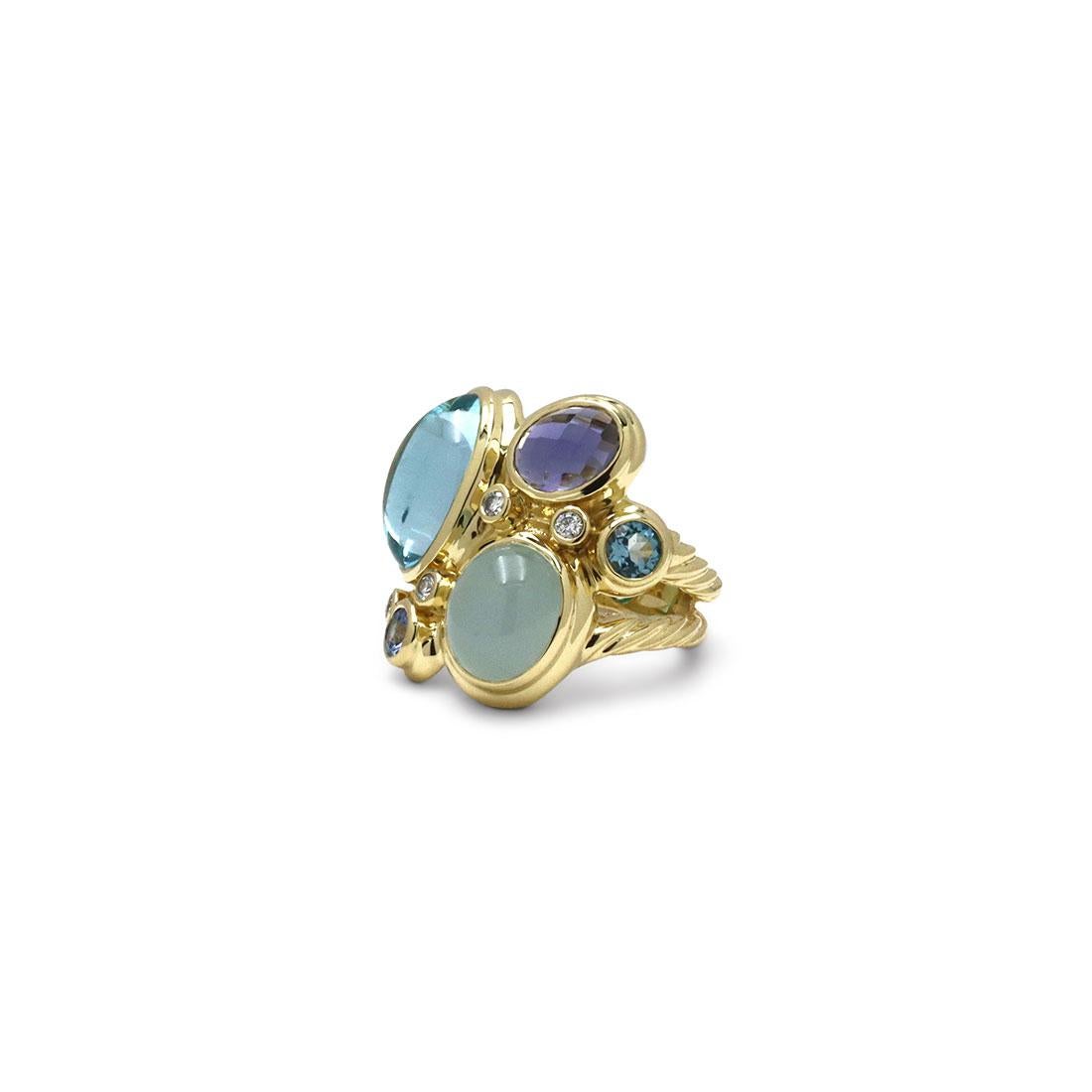 Authentic David Yurman Mosaic ring crafted in 18 karat yellow gold. Set with cabochon blue topaz and milky aquamarine, faceted iolite, London blue topaz and blue sapphire and accented by 4 round brilliant cut diamonds weighing an estimated 0.15