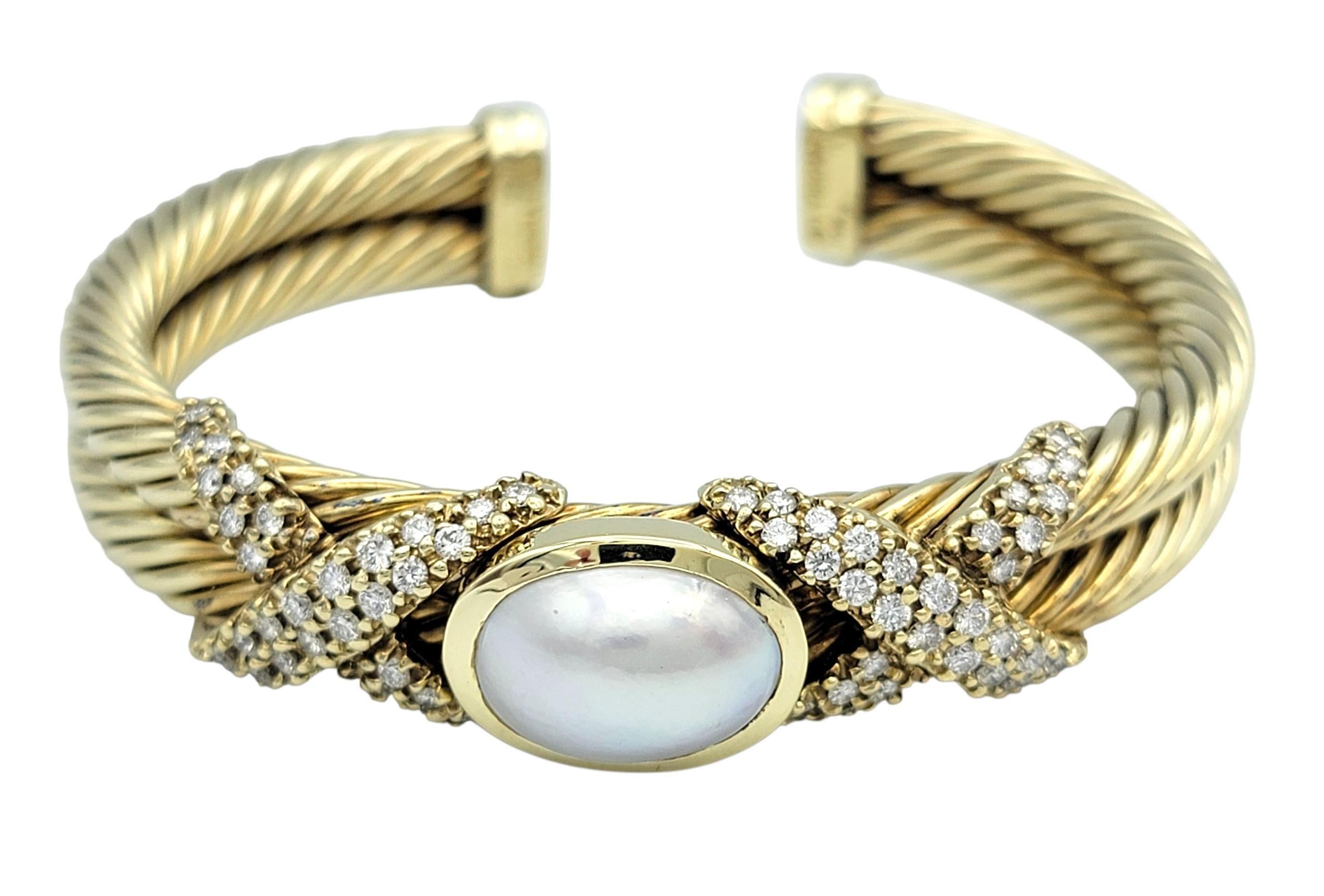 Cet authentique bracelet manchette à câble de David Yurman est une luxueuse fusion de design audacieux et de féminité gracieuse. Réalisé en or jaune 14 carats, le motif en câble signature s'enroule élégamment autour du poignet, mettant en valeur une
