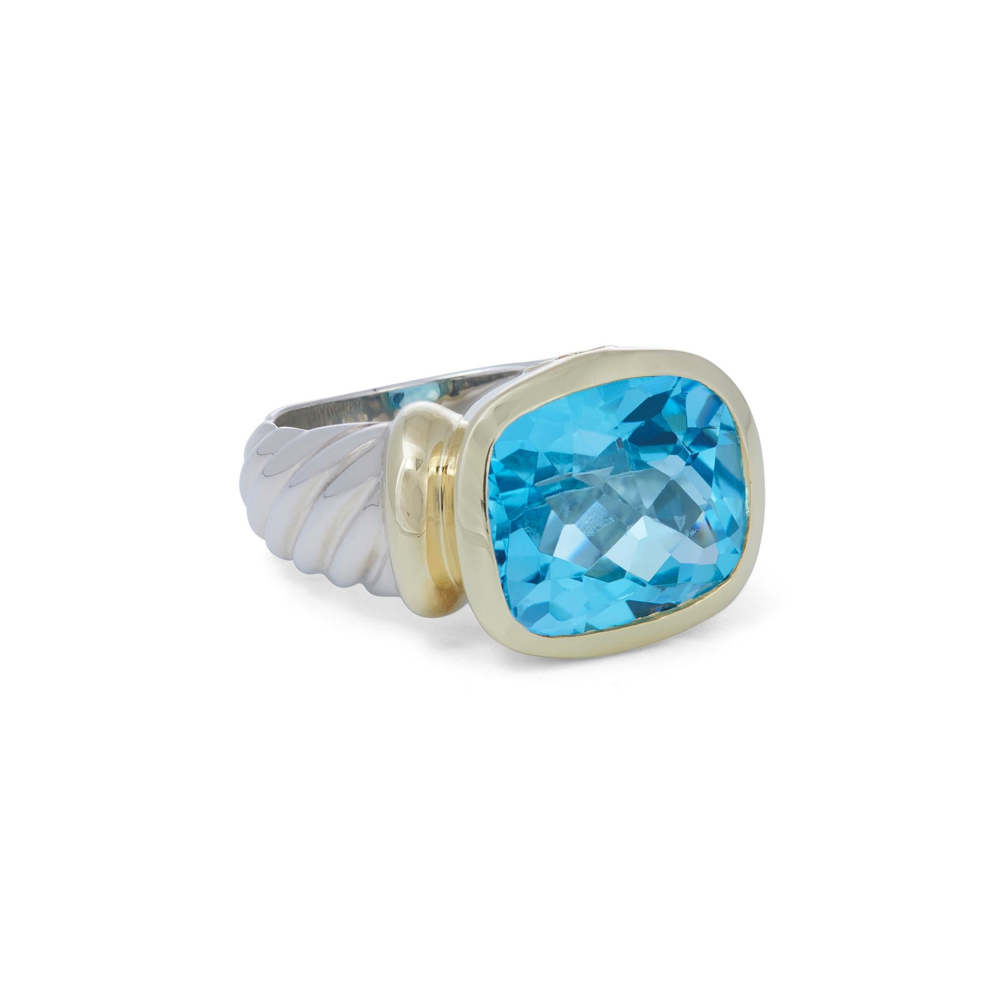 Authentic David Yurman ring from the 'Noblesse' collection. Crafted in sterling silver with an 14 karat yellow gold centerpiece set with a faceted blue topaz stone.  US size 6 1/4.  Signed D. Yurman, 585, 925, with hallmark.  Ring is not presented