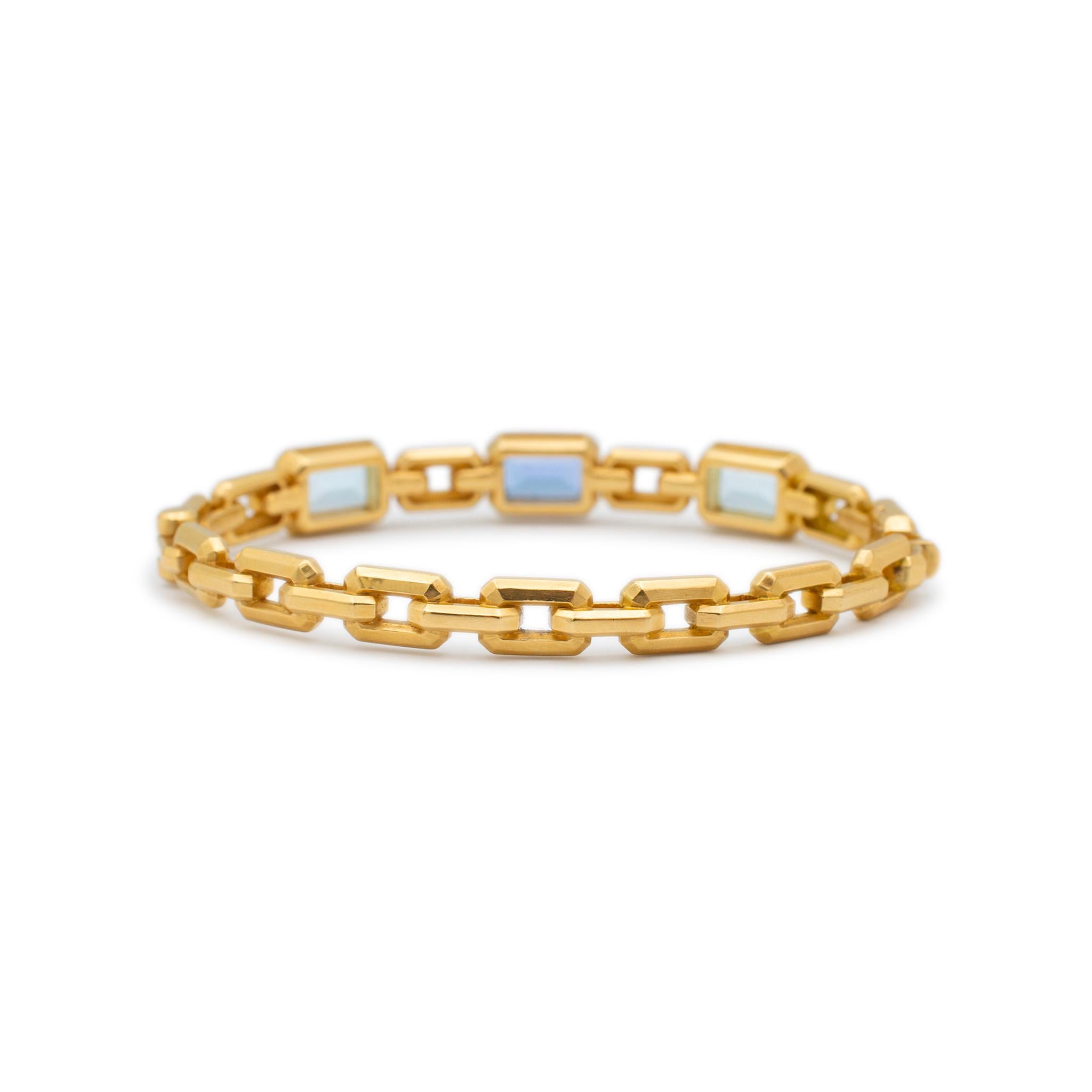Brand: David Yurman

Gender: Ladies

Metal Type: 18K Yellow Gold

Length: 6.00 inches

Width: 8.45 mm

Weight: 32.52 grams

18K yellow gold tanzanite and blue topaz bangle bracelet. The metal was tested and determined to be 18K yellow gold. Engraved