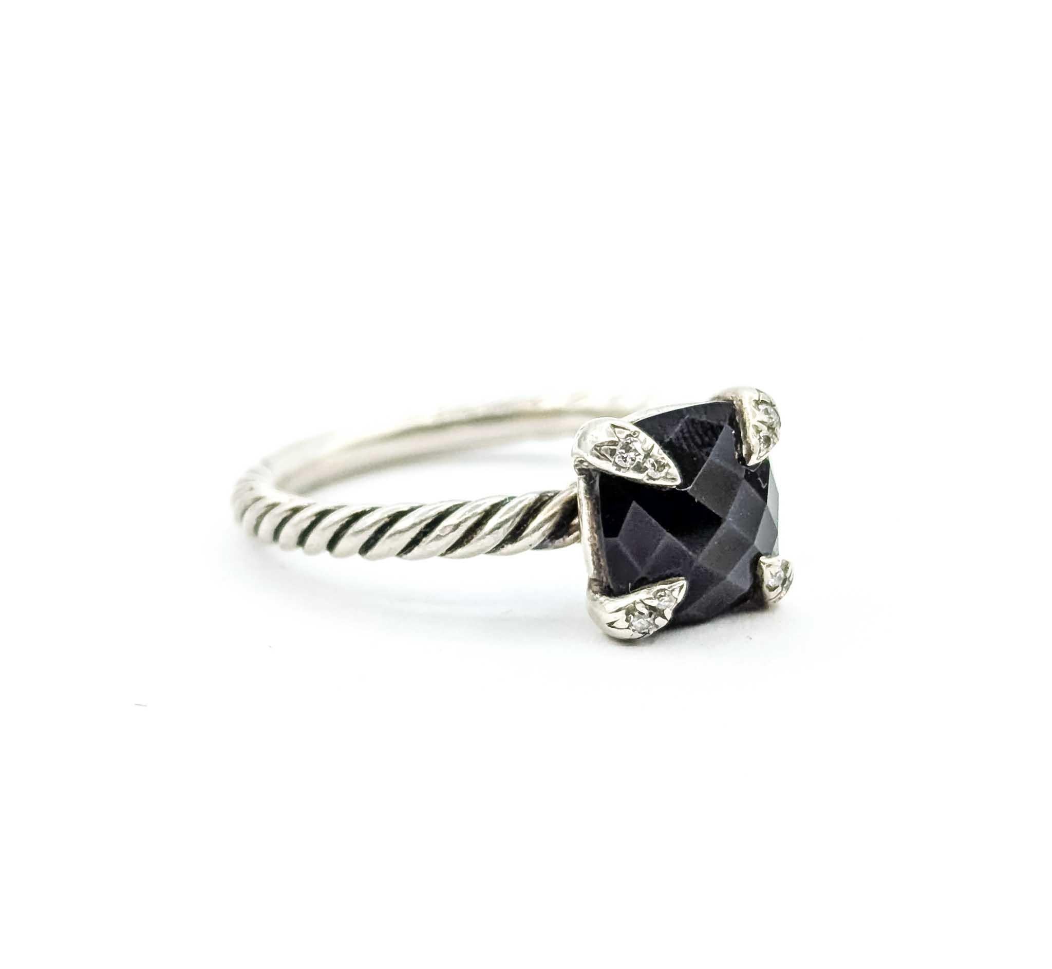 Questo iconico design David Yurman presenta un onice nero da 8 mm con taglio a cuscino incastonato in quattro griffe scolpite, ciascuna accentata da scintillanti diamanti rotondi per un totale di 0,04 carati. Realizzato in argento sterling, l'anello