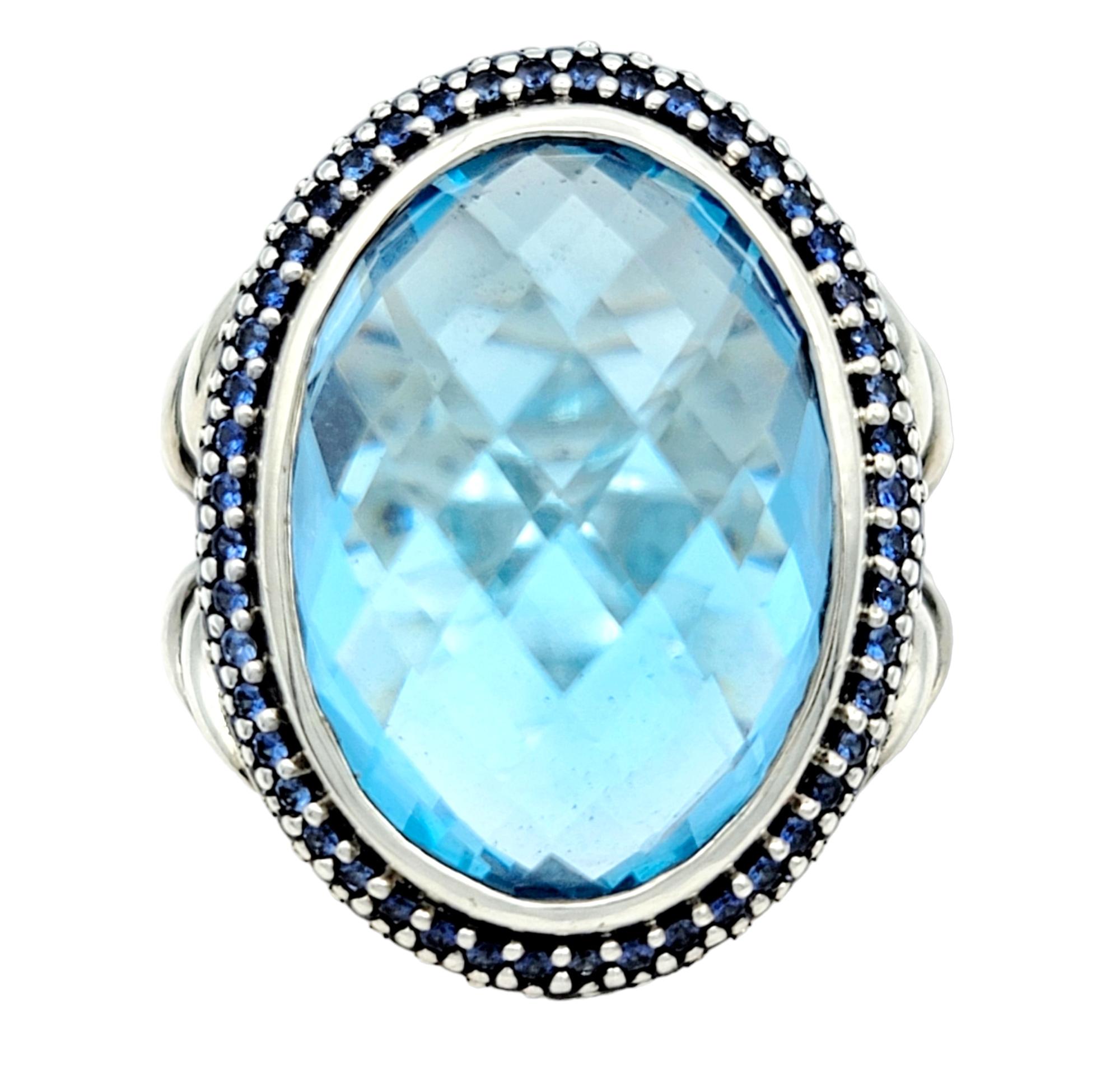 Ring Size: 4

Step into a world of understated glamour with this designer sterling silver cocktail ring, a tasteful masterpiece that effortlessly marries simplicity with sophistication. At its core, a large resplendent oval blue topaz takes center