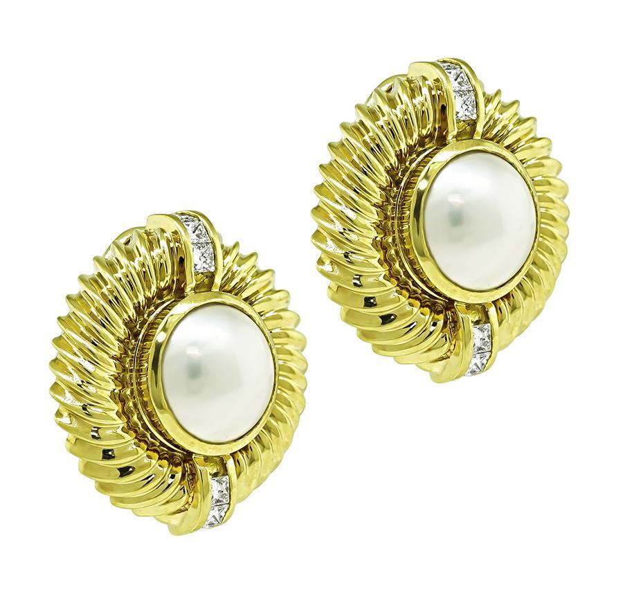 This is a stunning pair of 18k yellow gold earrings by David Yurman. The earrings feature lovely pearls at the center. The pearls are accentuated by sparkling princess cut diamonds that weigh approximately 0.50ct. The color of the diamonds is E with