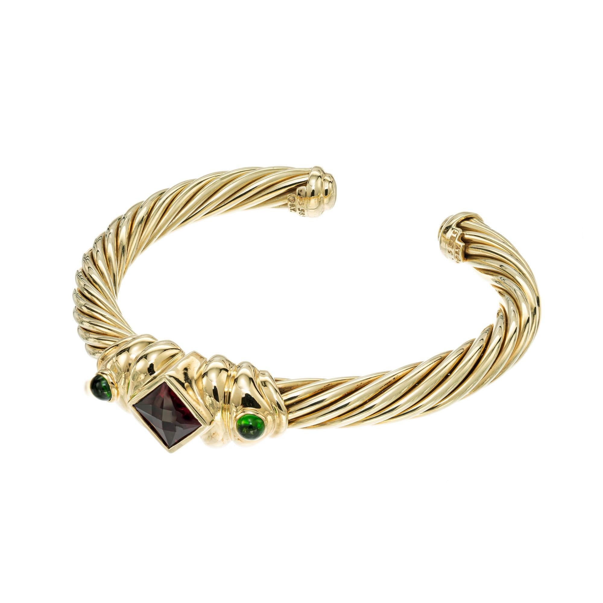 David Yurman Renaissance 14k yellow gold cuff bracelet with a rubellite tourmaline and tow cabochon green accent Tourmalines. fits up to a 7.5 inch wrist. 

1 faceted square brownish red Rubellite Tourmaline, 8x8mm
2 cabochon round green Tourmaline,