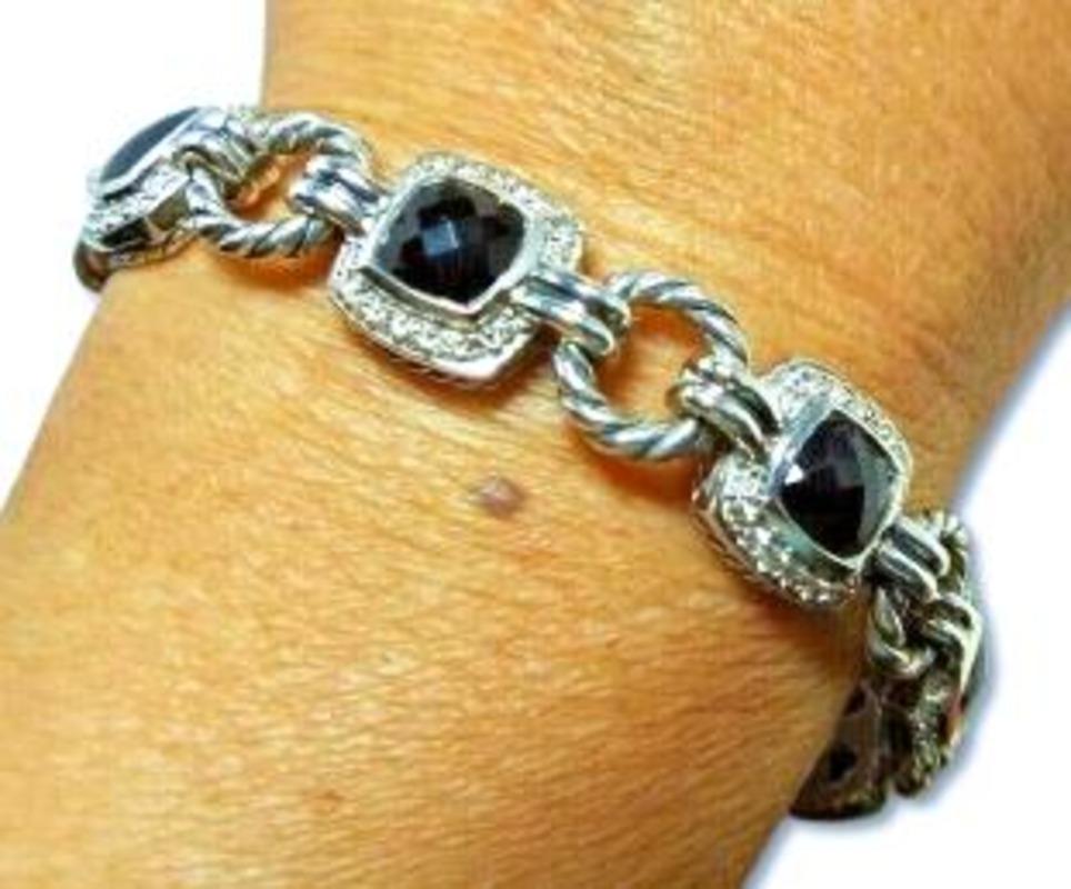 Eleganza nel gioco degli accessori con lo squisito bracciale David Yurman, un mix straordinario di eleganza moderna e raffinatezza senza tempo. Realizzato in argento sterling di prima qualità, questo pezzo è caratterizzato da pietre di onice nero di